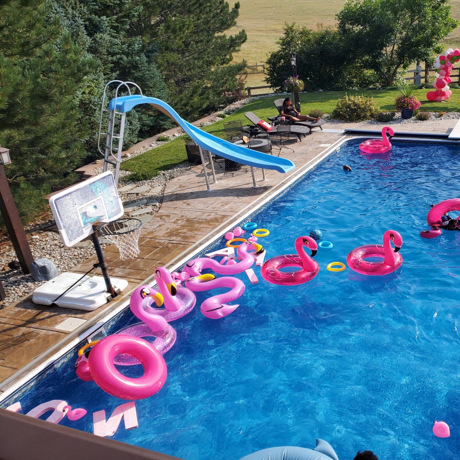 backyard pool with lots of pink floaties