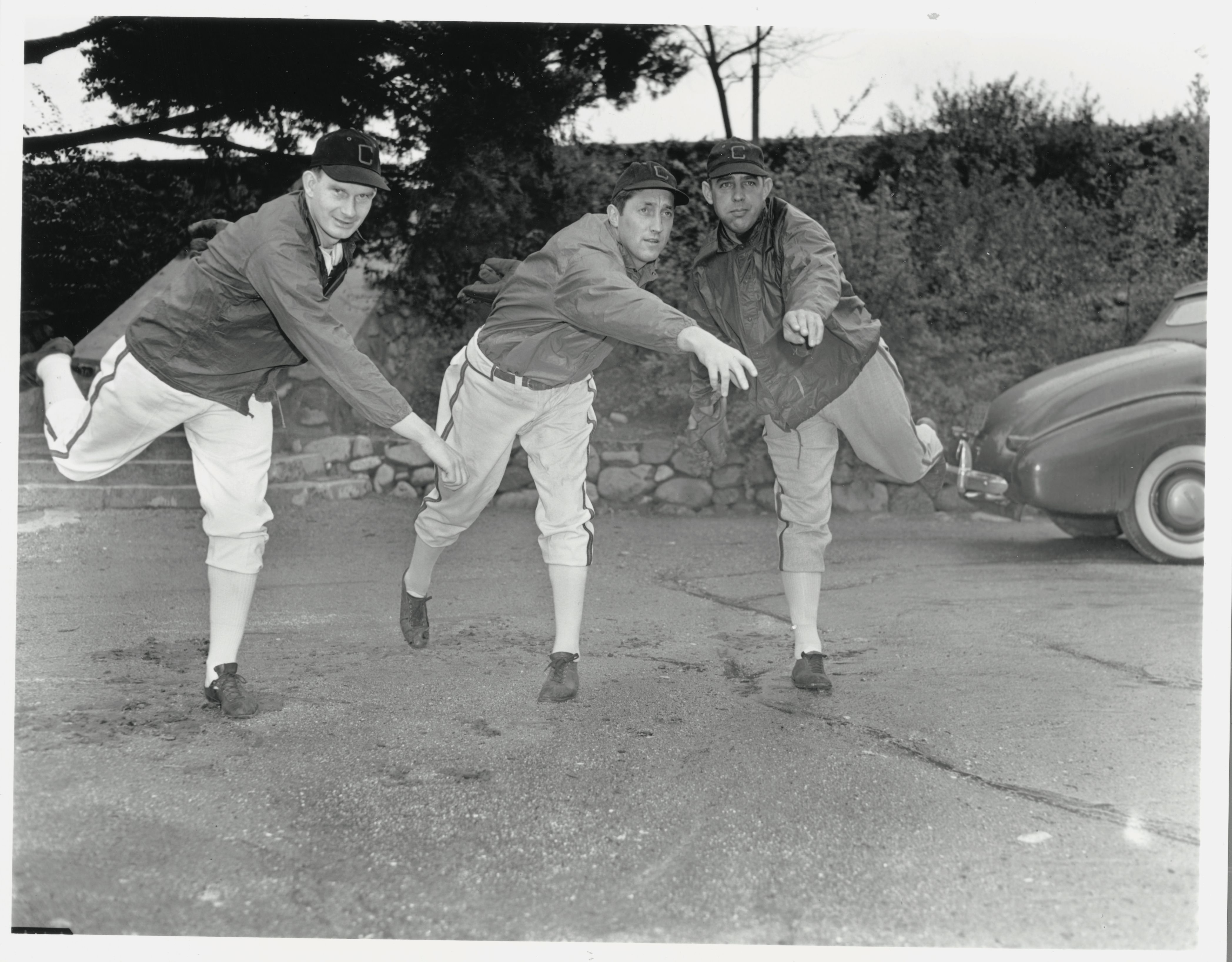 Photo of three men throwing baseballs. 