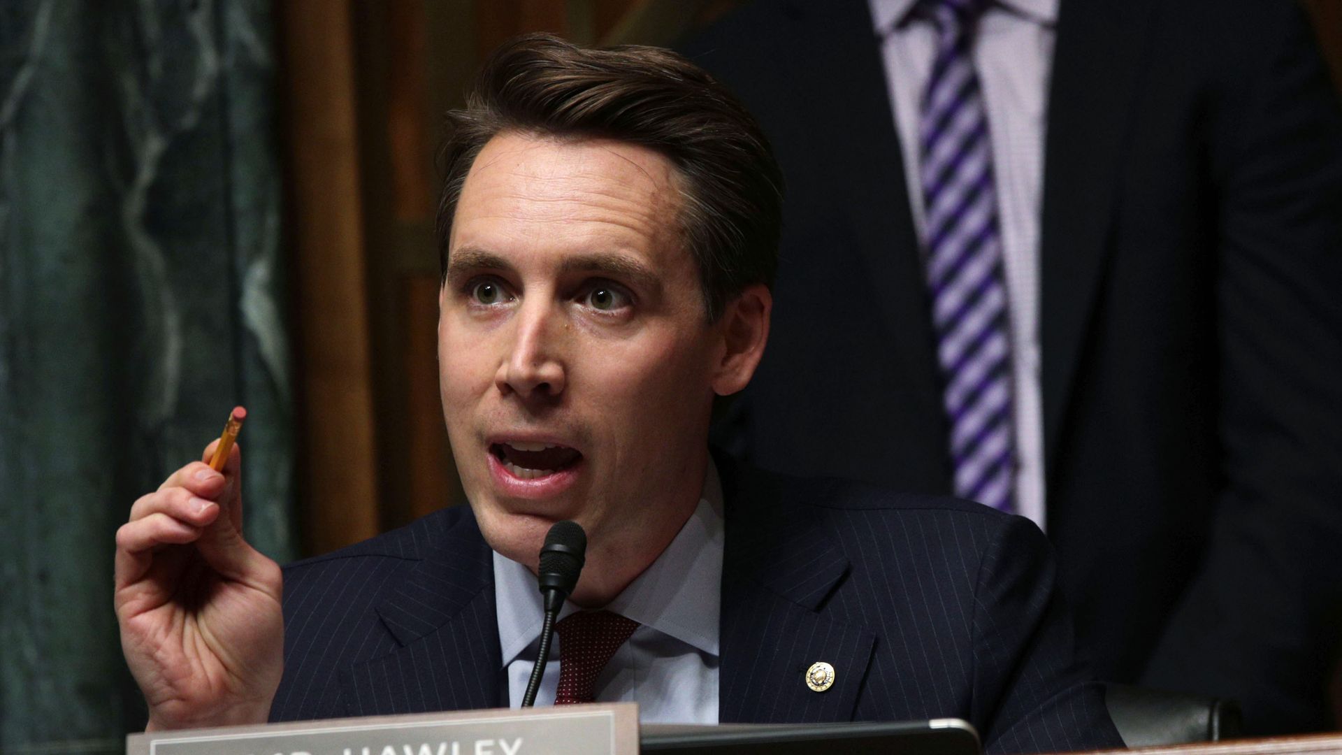 A man in a suit speaking