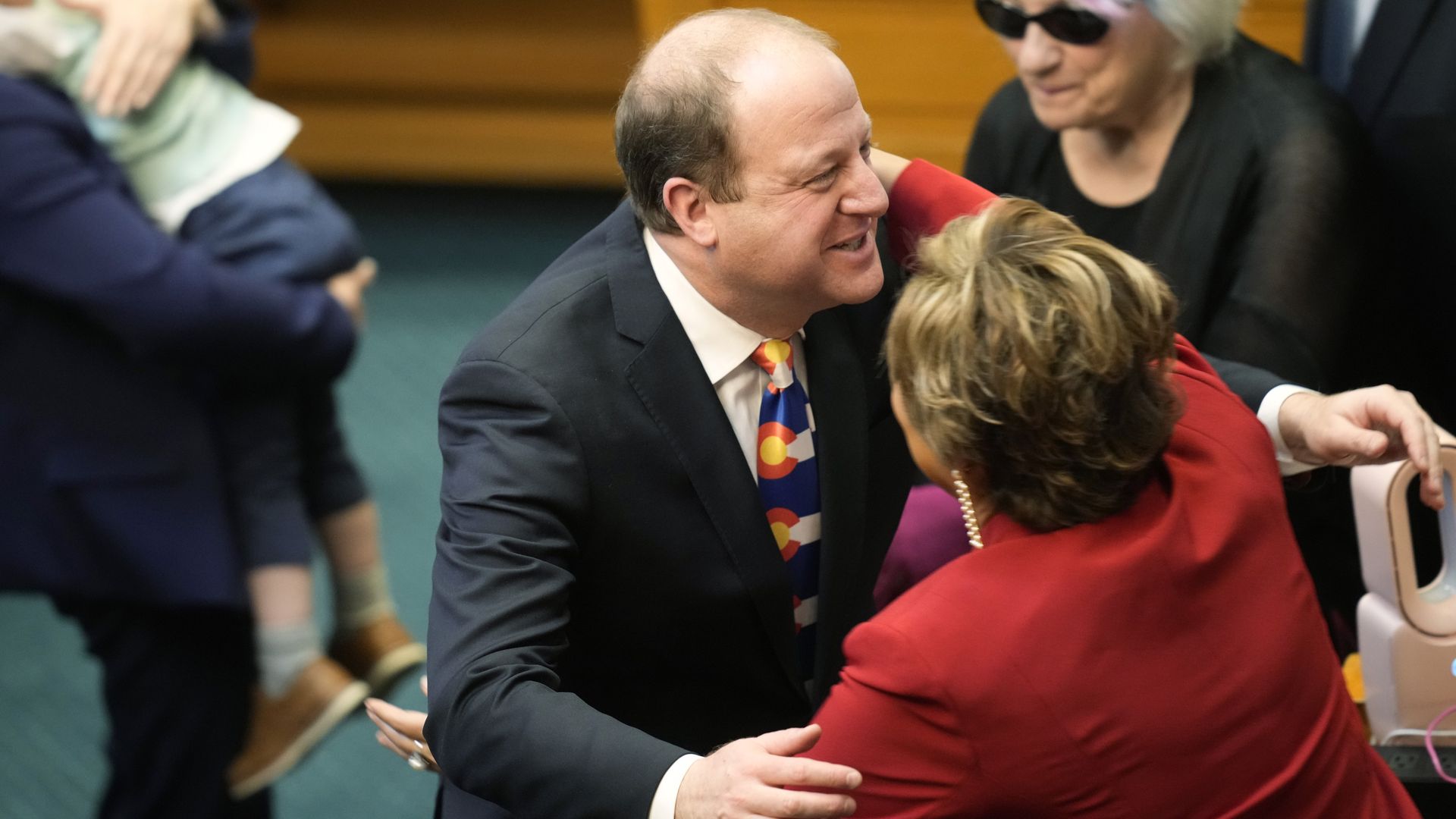 Colorado Gov. Jared Polis, center, hugs state Rep. Monica Duran, D-Wheat Ridge, after delivering his State of the State on Tuesday. Photo: David Zalubowski/AP