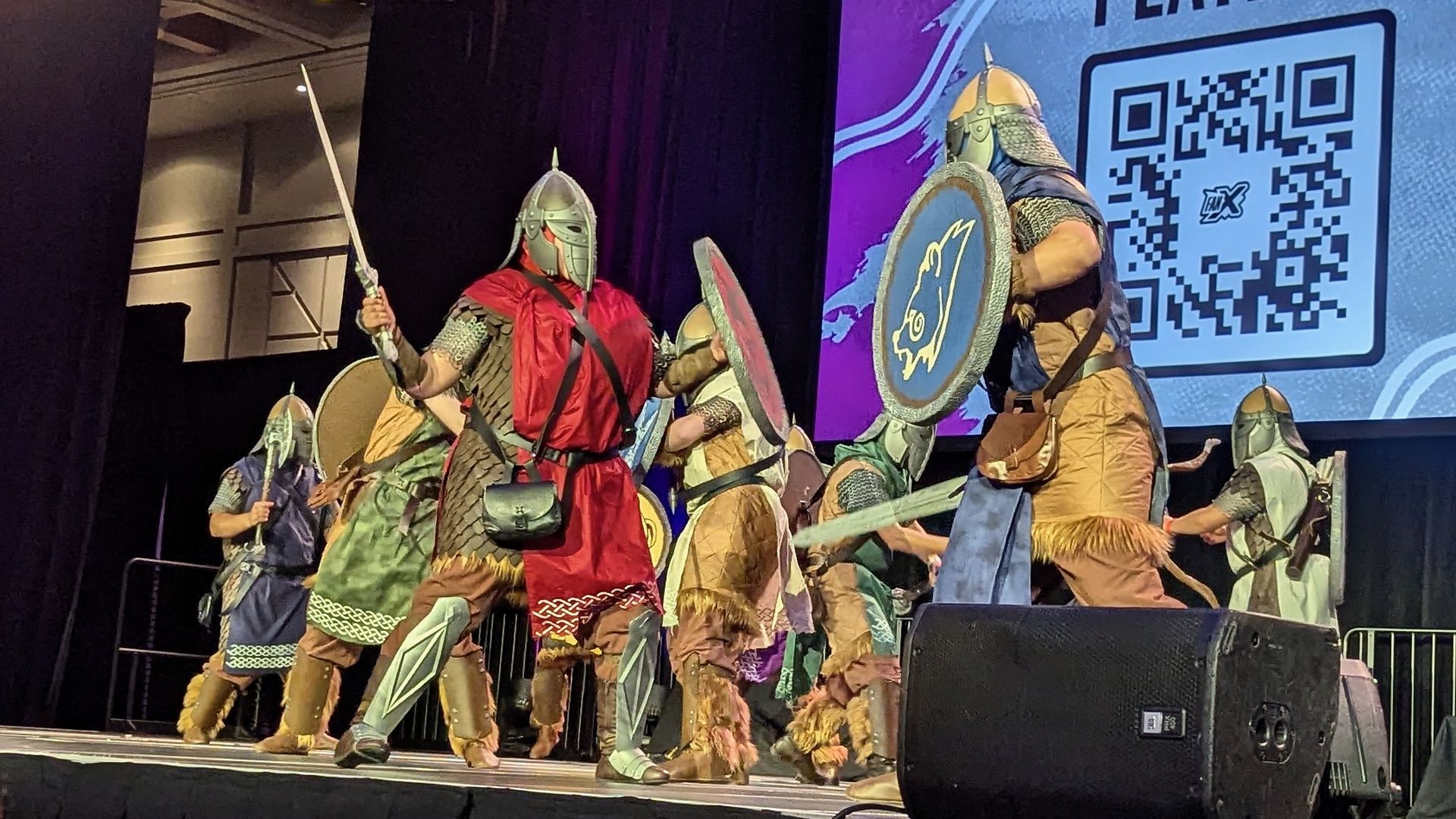People dressed as knights fight with each other on a stage