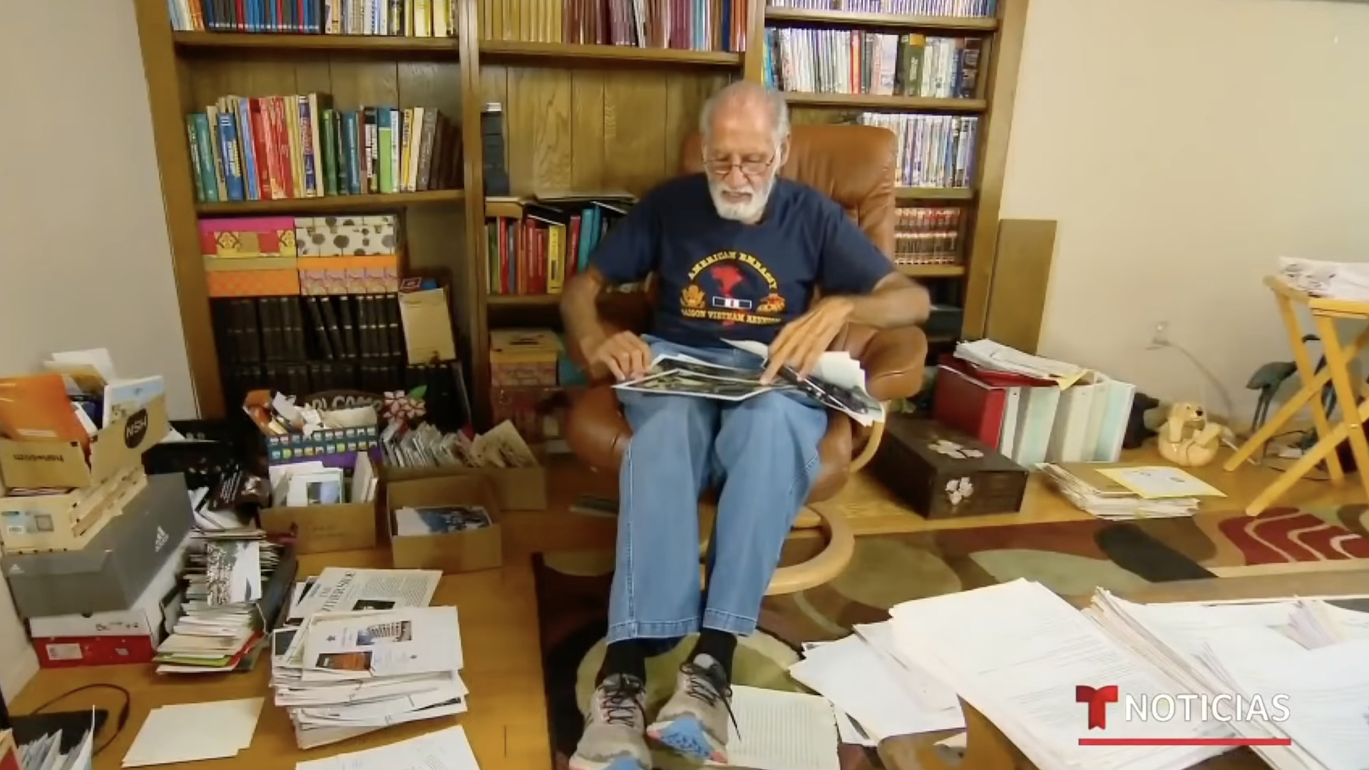 Juan José Valdez the last U.S. Marine off the roof of Saigon's U.S. Embassy, looking at photos at his Southern California home.