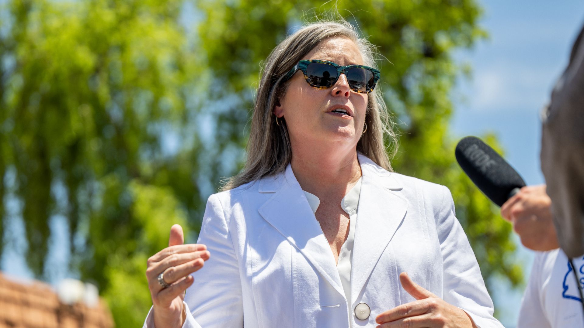Katie Hobbs gestures with her hands while speaking to reporters