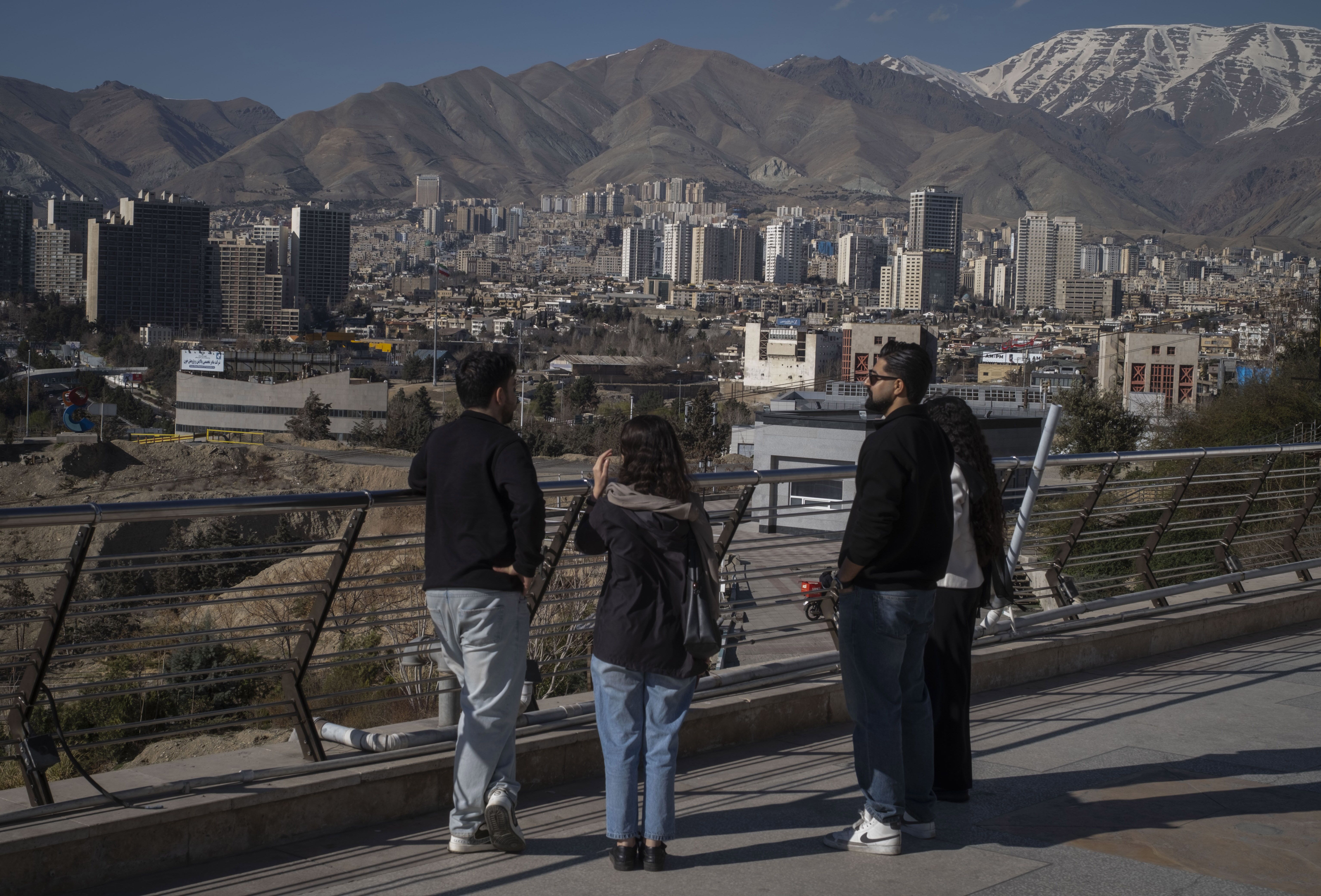 Iranian youths stand together in front of a view of Tehran, Iran, on February 26, 2026, the final day of Iran-U.S. talks that are currently held in the city of Geneva. (Photo by Morteza Nikoubazl/NurPhoto via Getty Images)