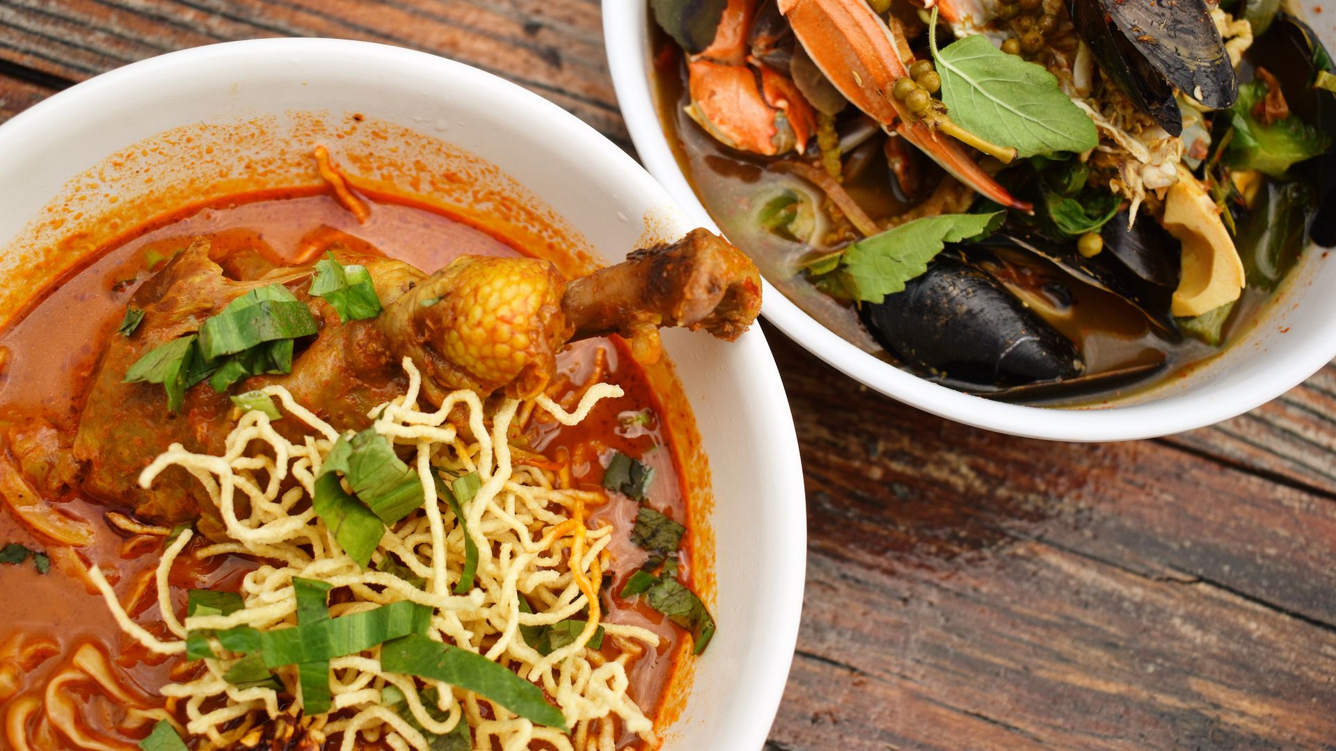 A Thai red curry noodle bowl and a seafood bowl with crab and mussels 