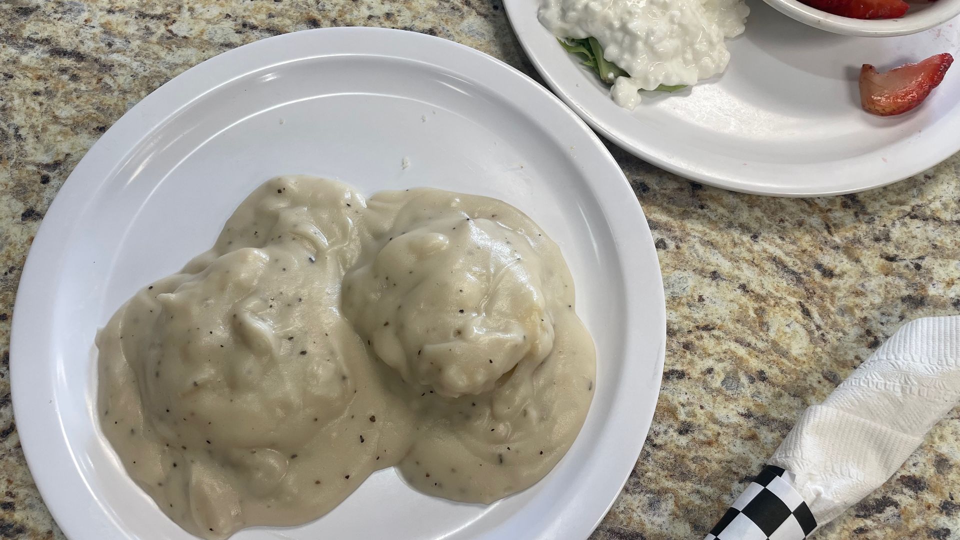 A plate with a biscuit covered in gravy