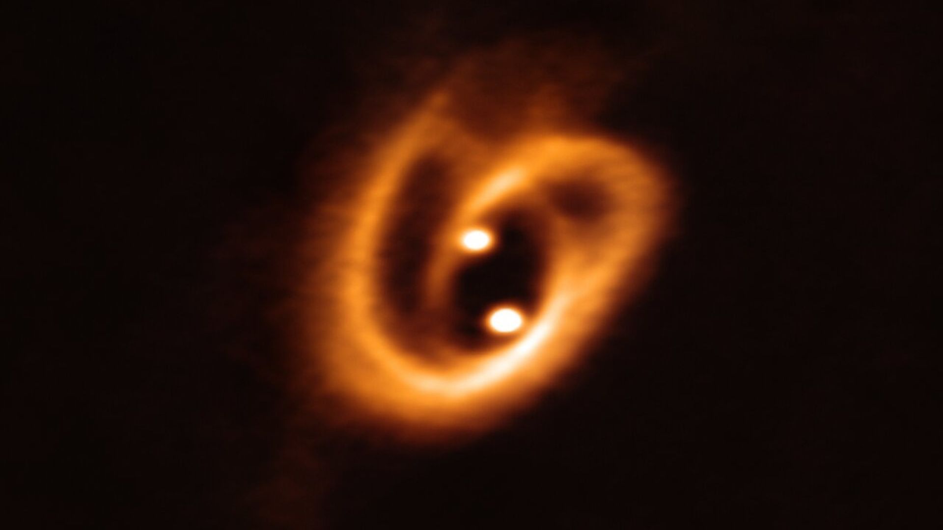 Two baby stars being born in a nebula in orange
