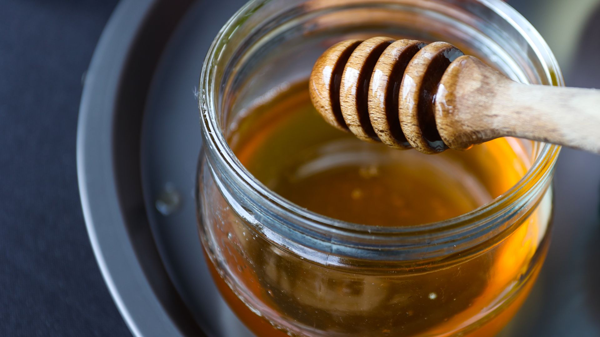 A jar of honey and a honey dipper