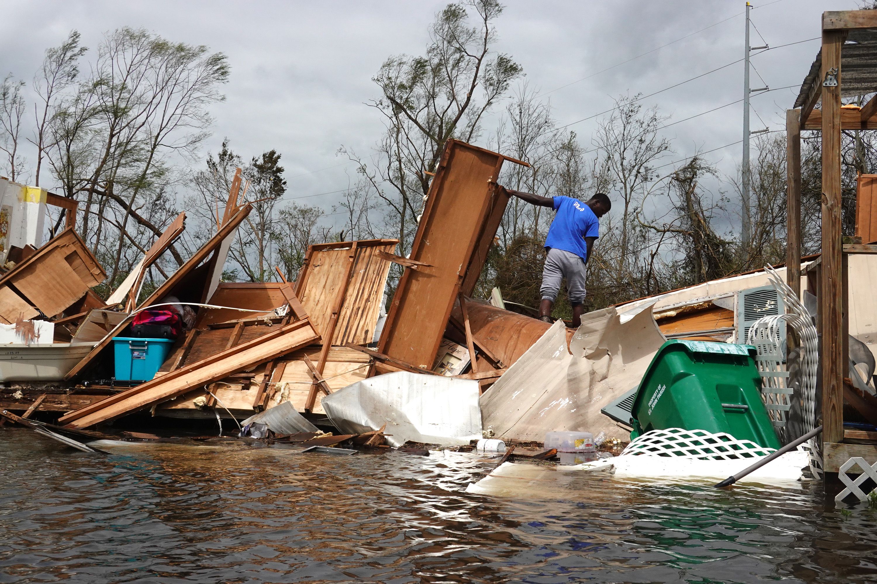 A person rescuing items from a home devastated by Hurricane Ida in LaPlace, Louisiana, in August 2021.