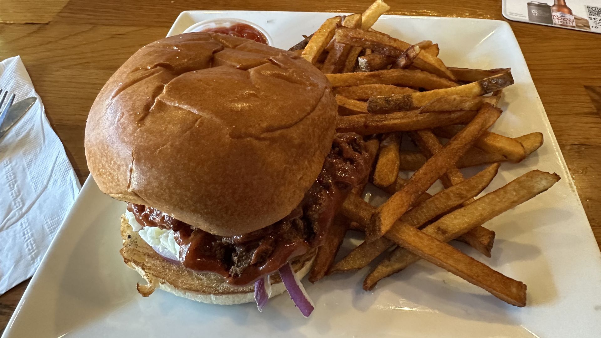 A plate with a buffalo chicken tender burger and a heap of fries, a $5 lunch special at Penguin Pizza in Boston.