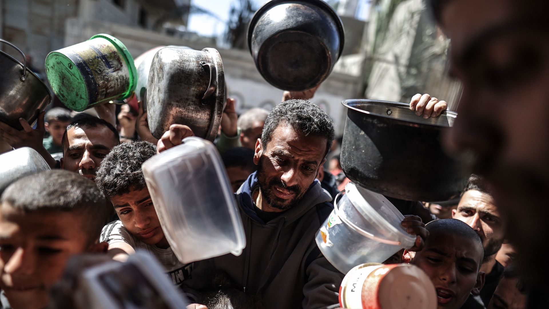Palestinians hold pots in line