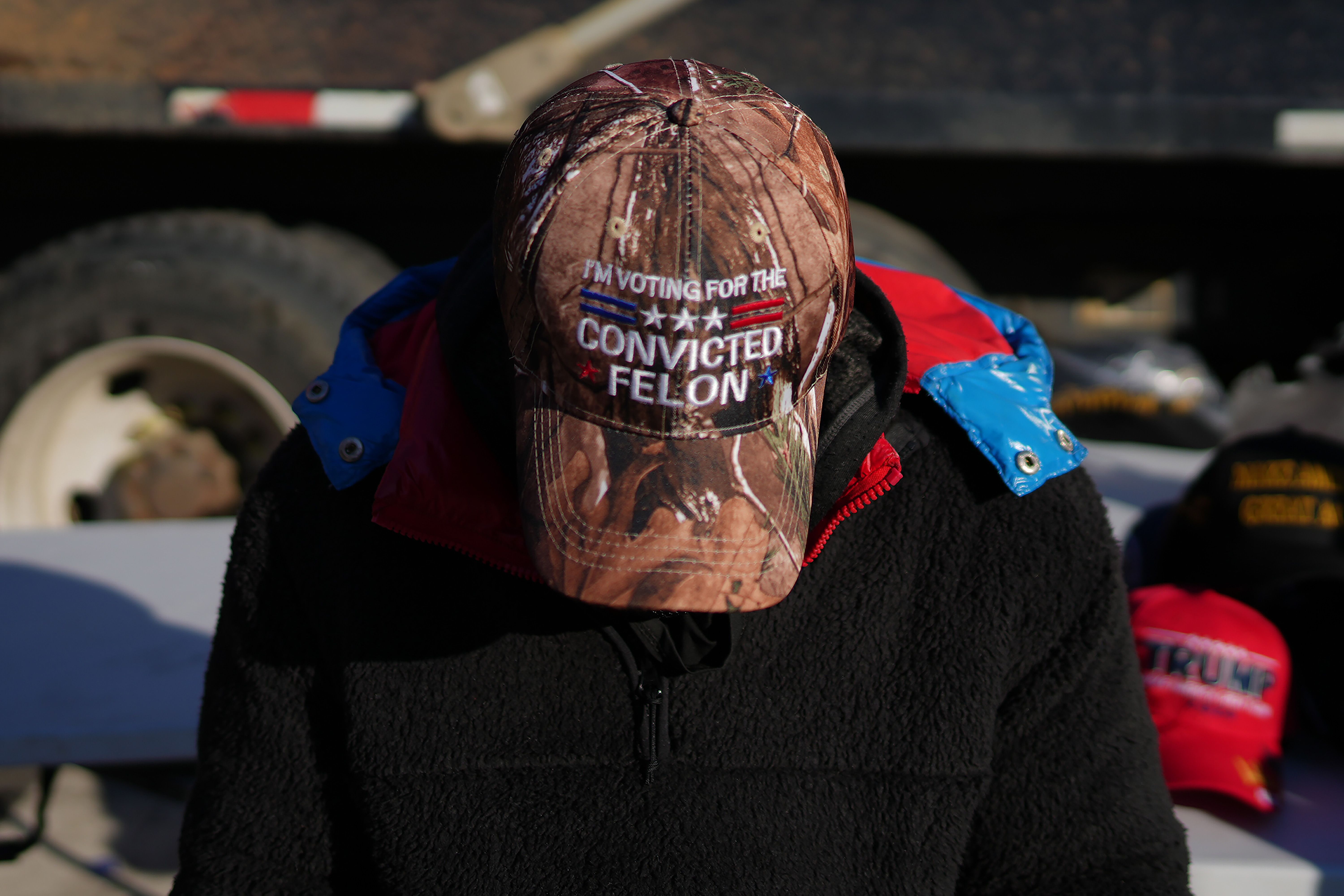 A photo of a man wearing a baseball cap that reads "I'm voting for the convicted felon."