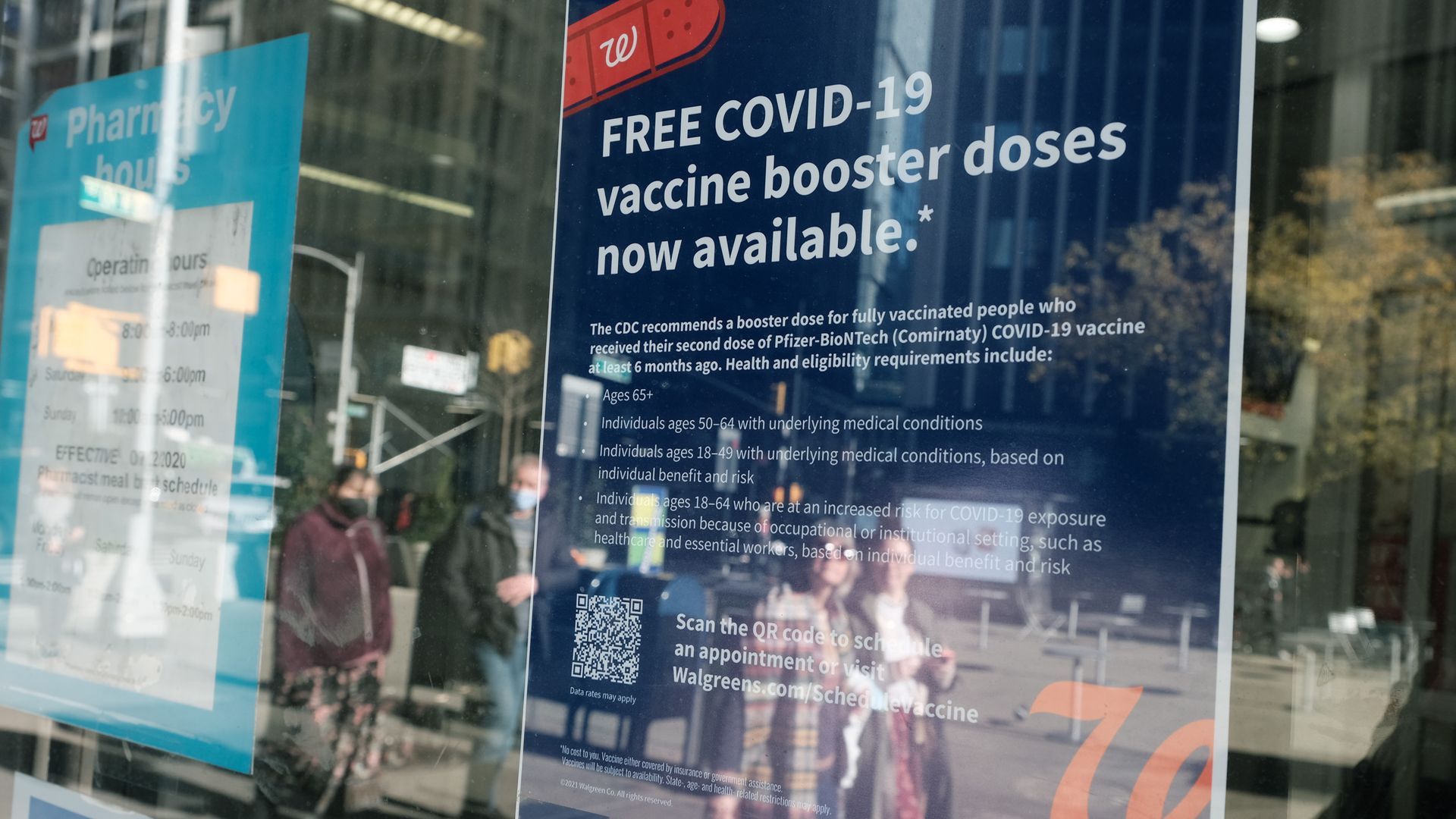 A blue sign inside a Walgreens pharmacy advertising COVID booster shots.