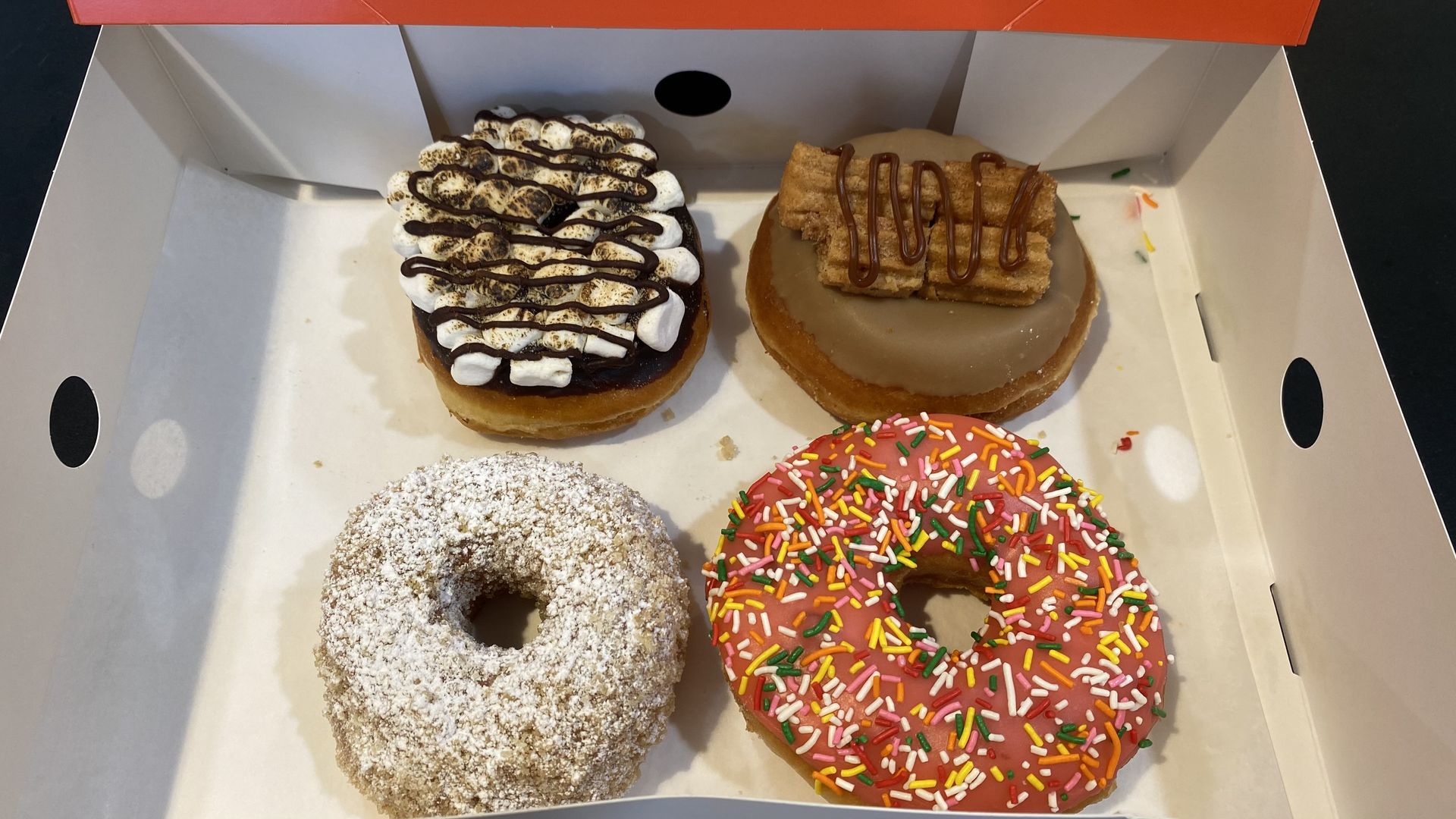 Four donuts arranged in a box.