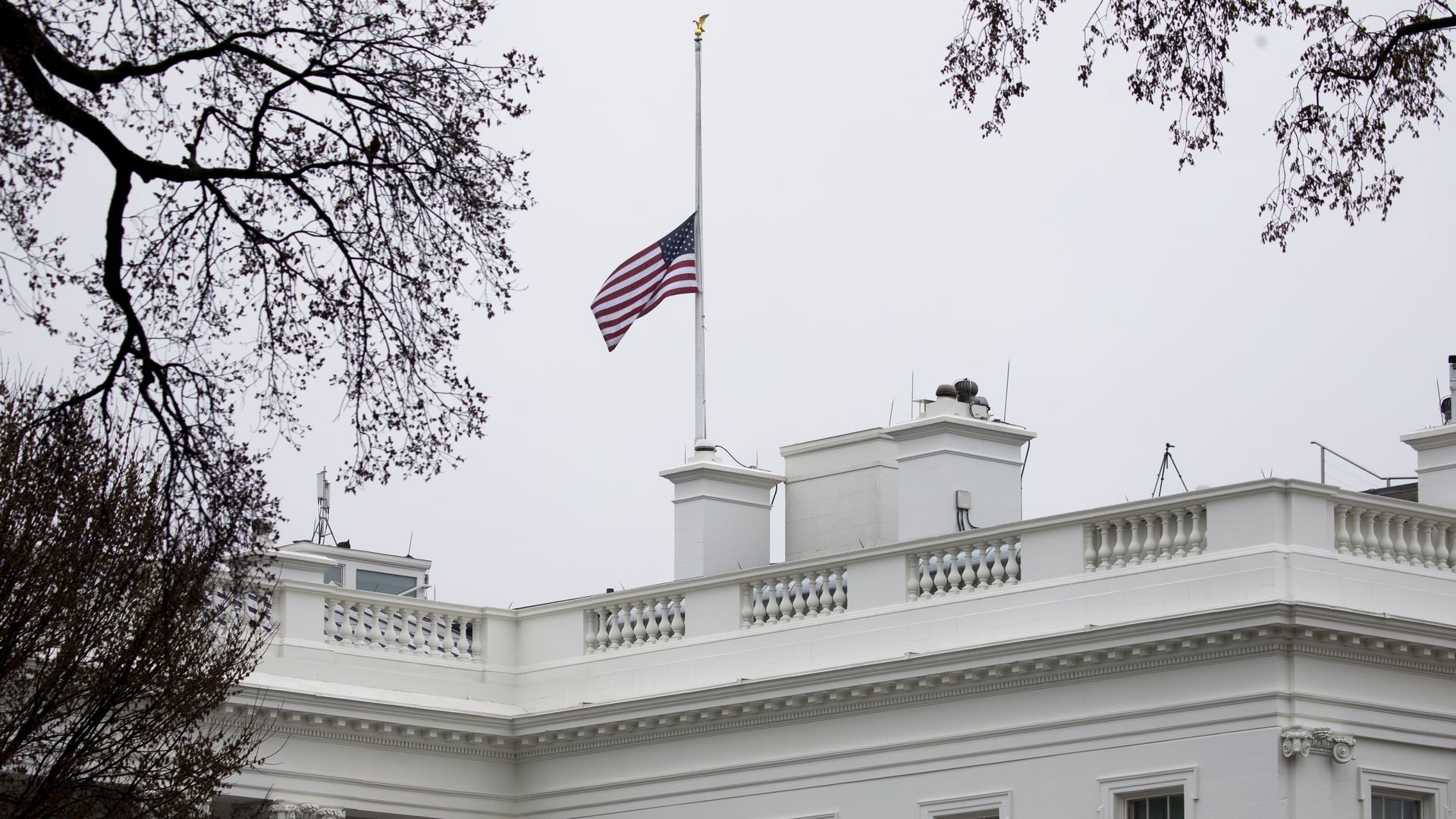 Picture of a flag flying at half-staff over the White House to honor the Atlanta victims