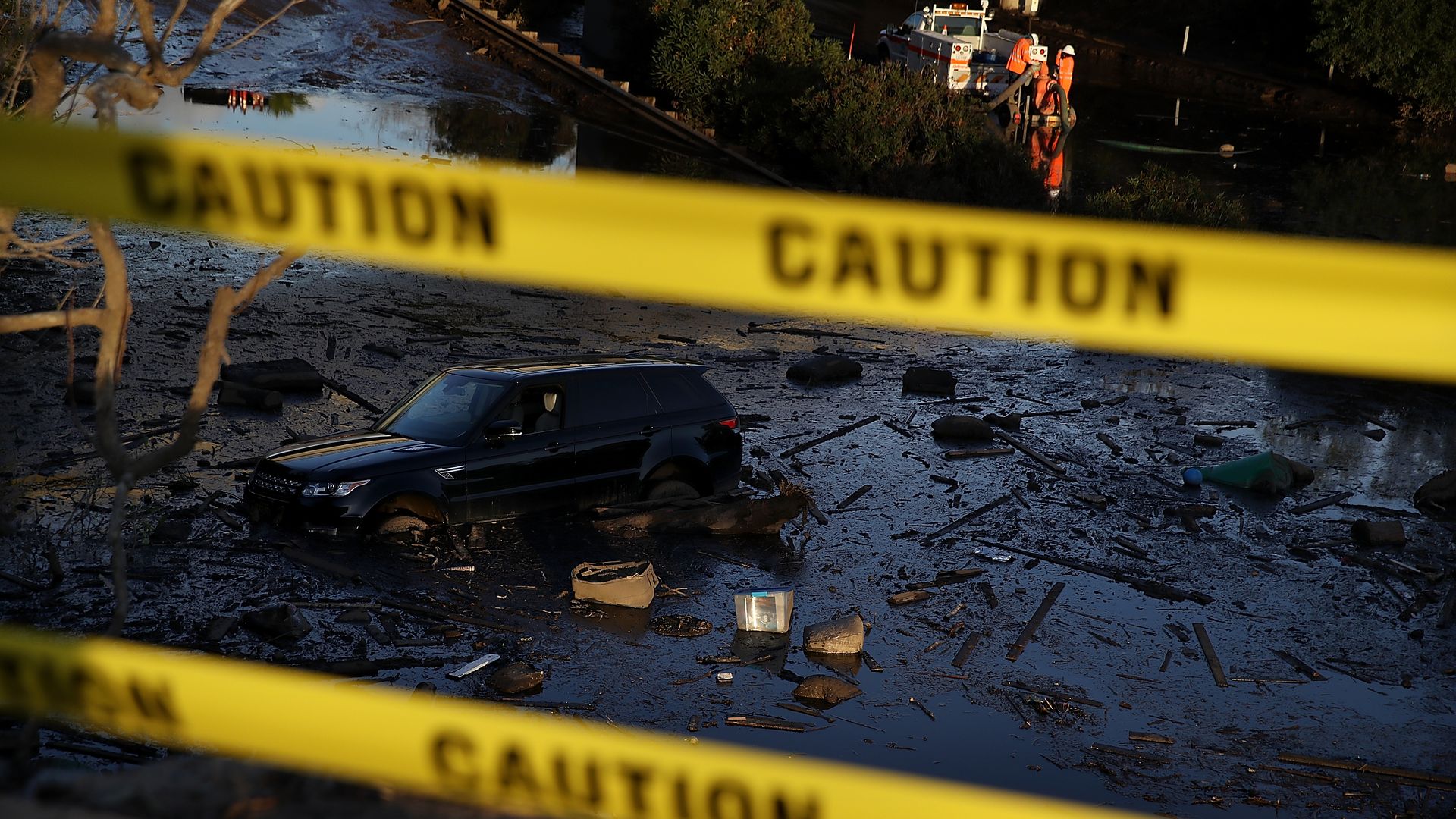 A car sits in mud and debris on Highway 101
