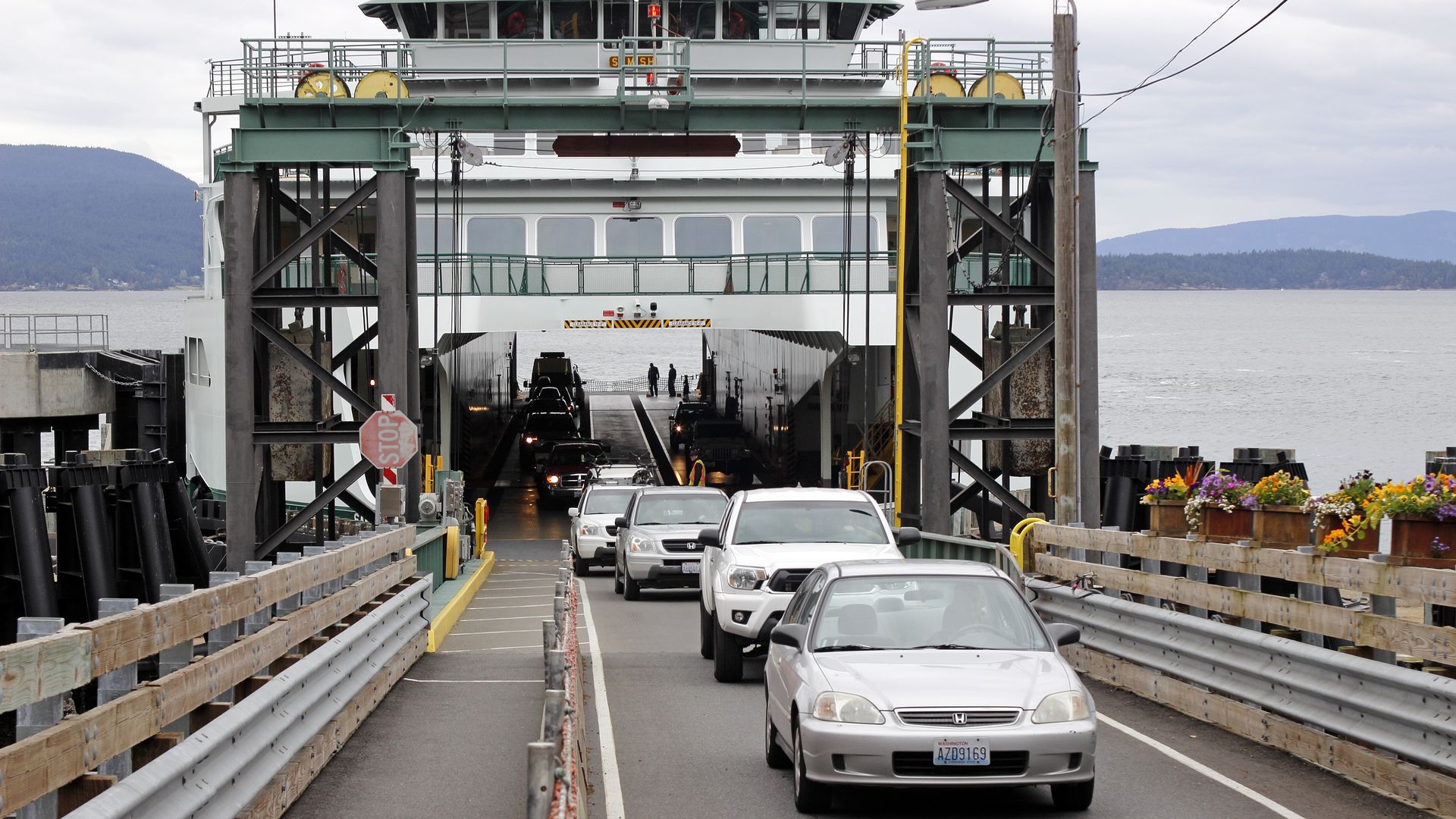 Cars driving off of a ferry.