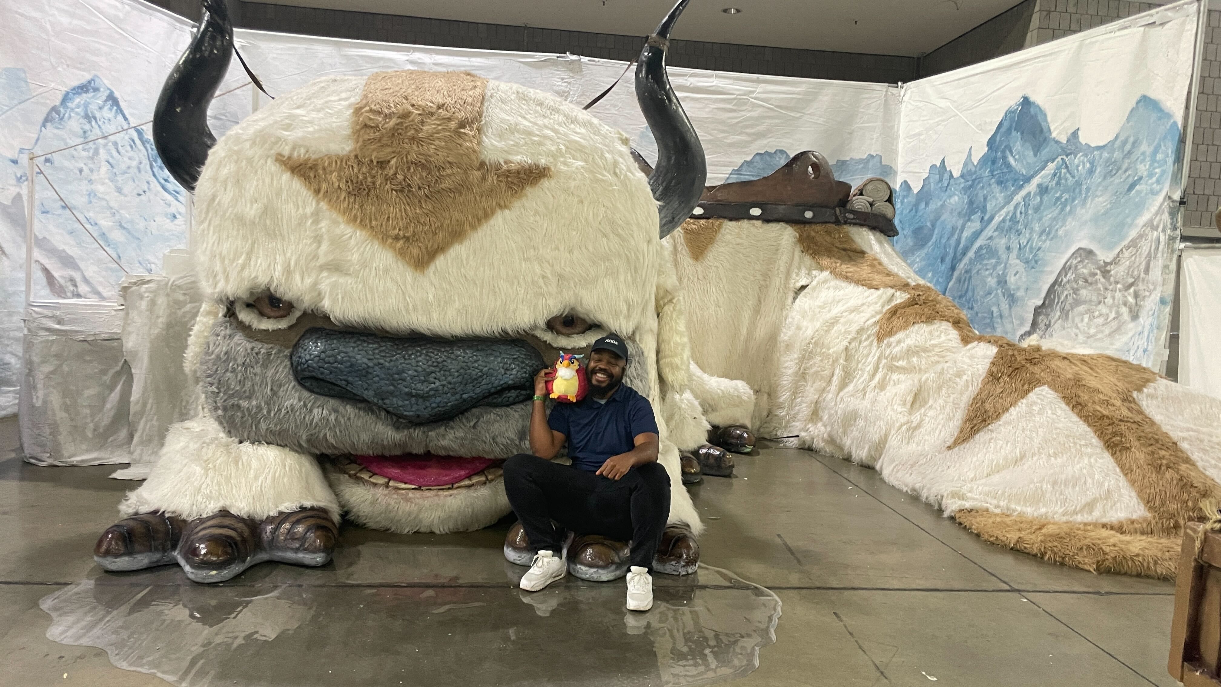 Axios's Wil Nobles and Phoenix 3000 pose with a life-sized version of the air bison Appa from "Avatar: The Last Airbender."