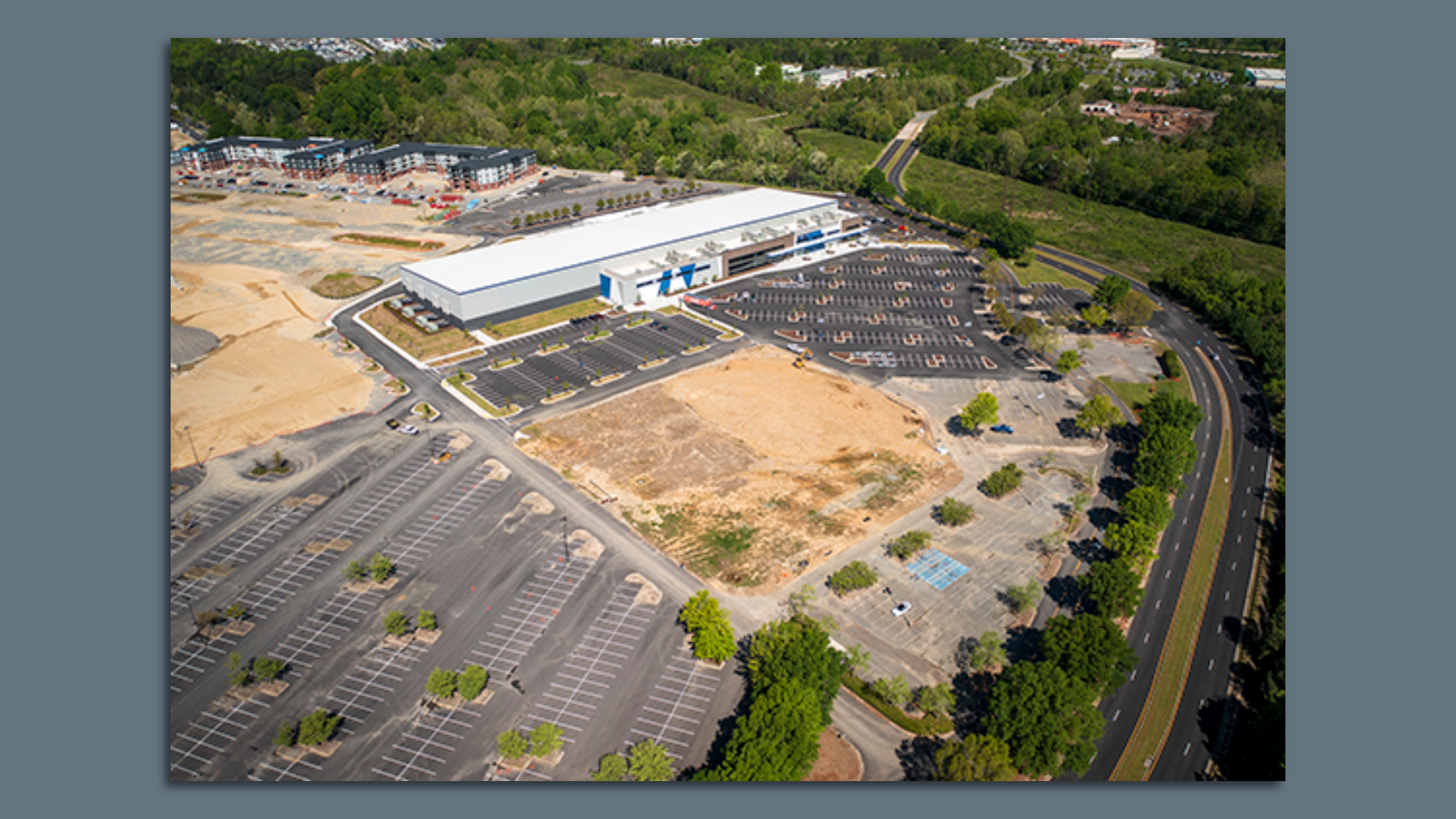 An aerial view of an empty lot with 1 big building 