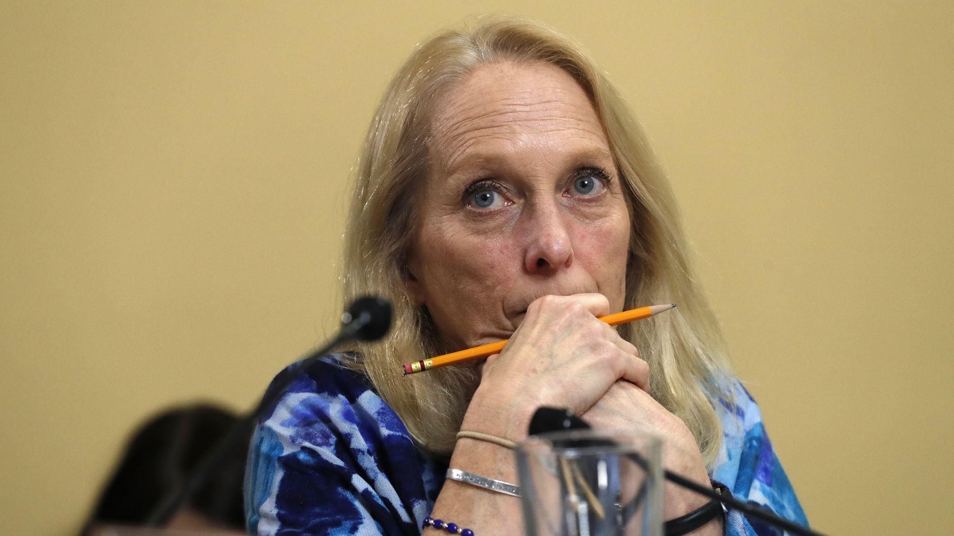 Photo of Mary Gay Scanlon with one hand positioned near her mouth as she listens