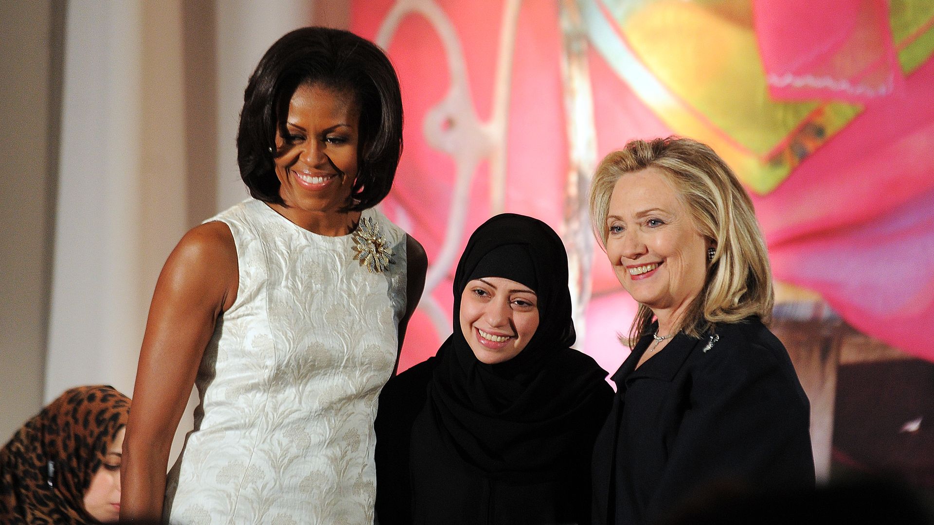 Saudi human rights activist Samar Badawi accepting an award next to Michelle Obama and Hillary Clinton