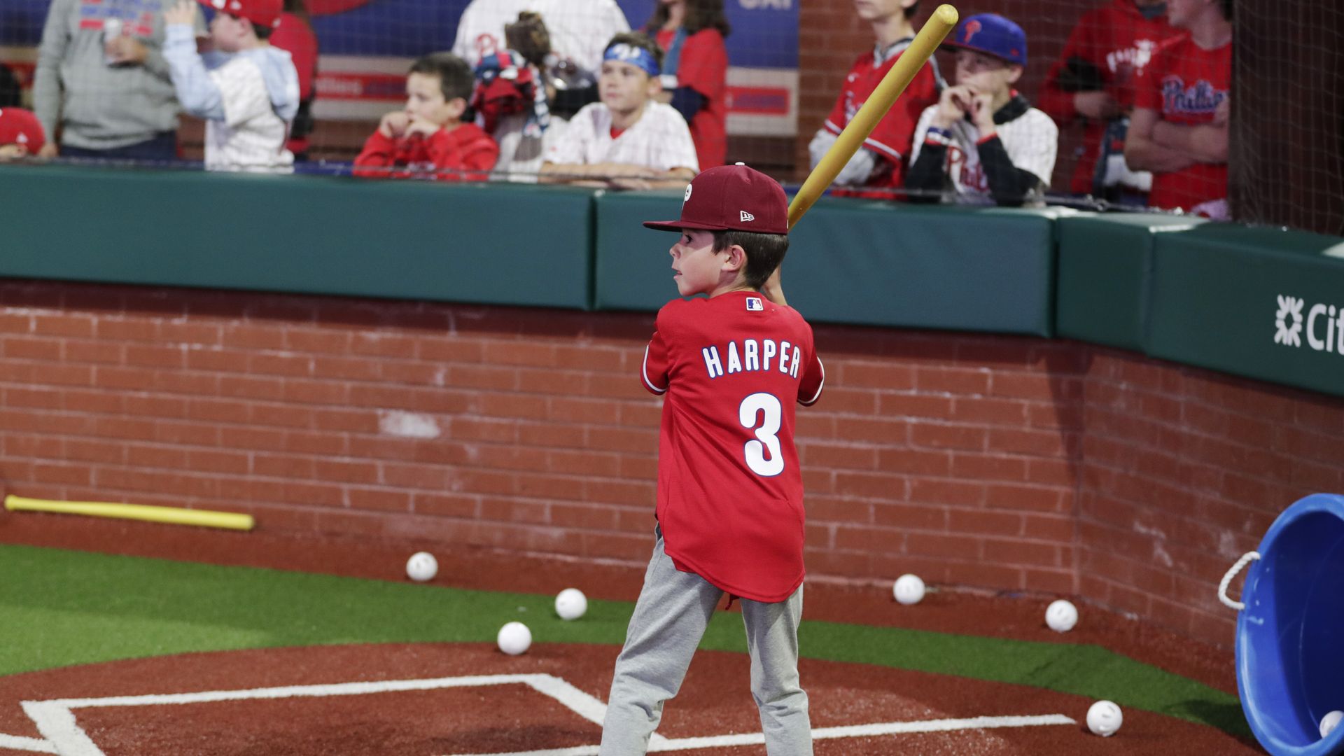 A young Phillies fan bats before a playoff game at Citizens Bank Park.