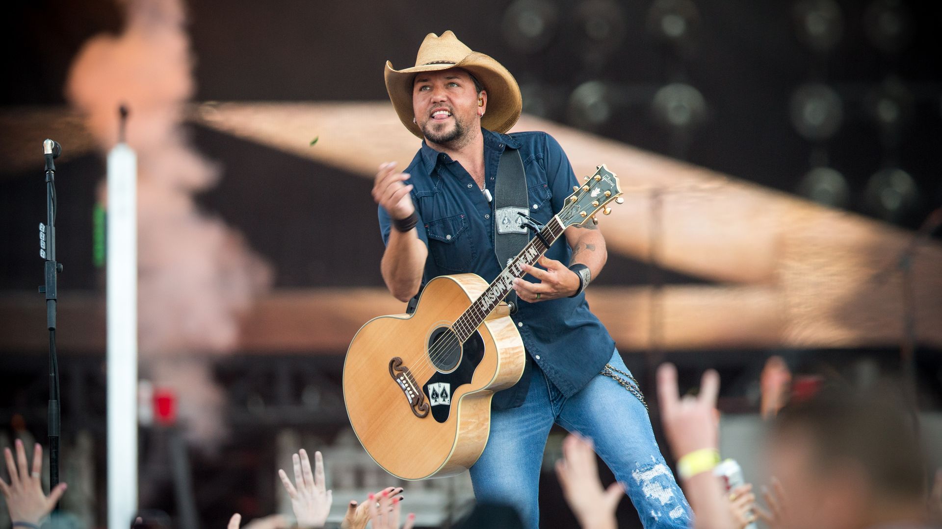 Jason Aldean flicks his guitar pick into a crowd.