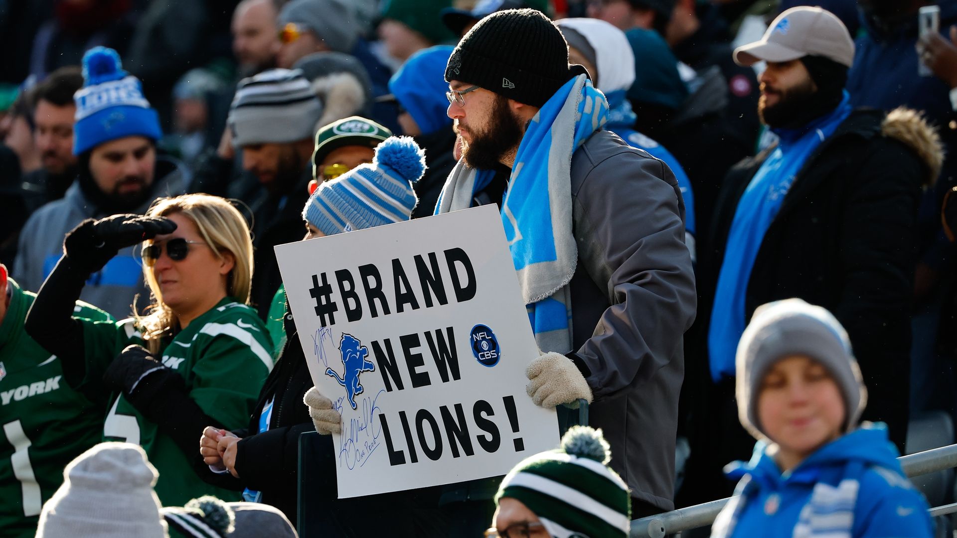 Detroit Lions fan in the stands holds up a sign that says #Brand New Lions at the Jets game