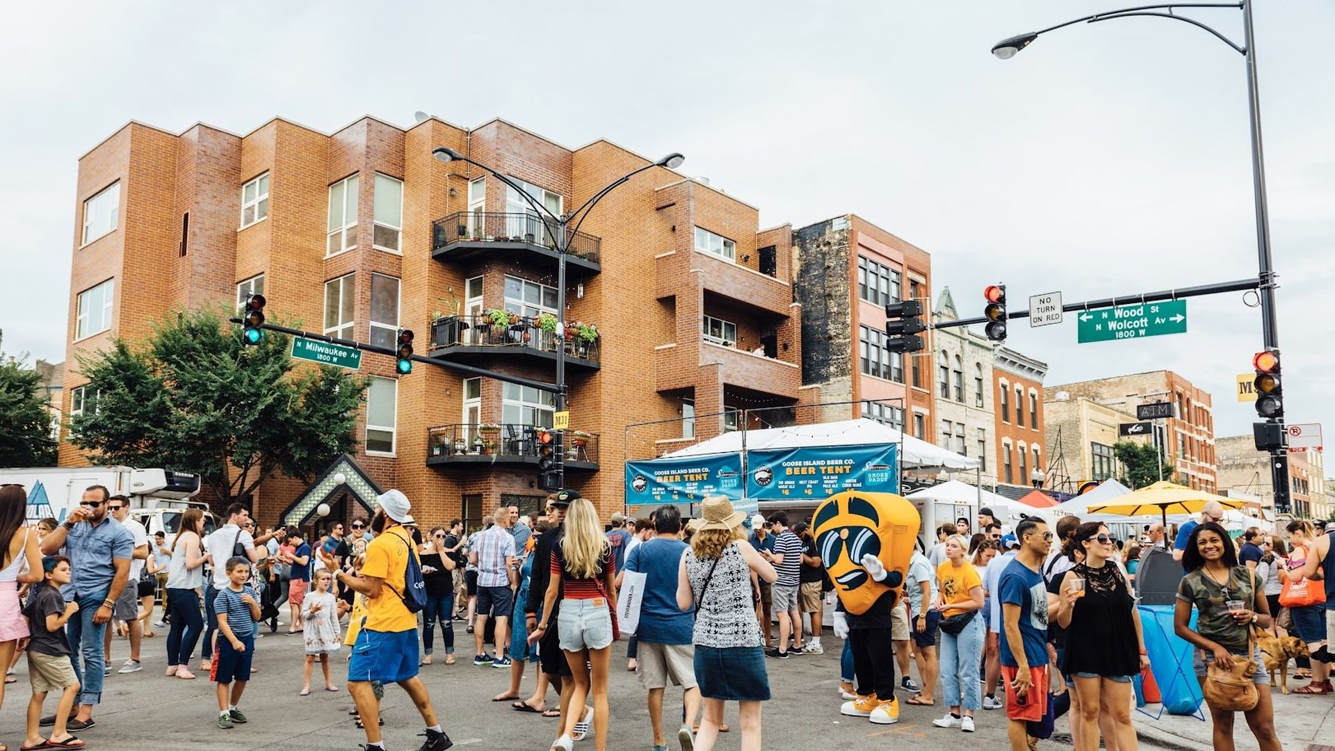 People walking around an intersection at a street festival.