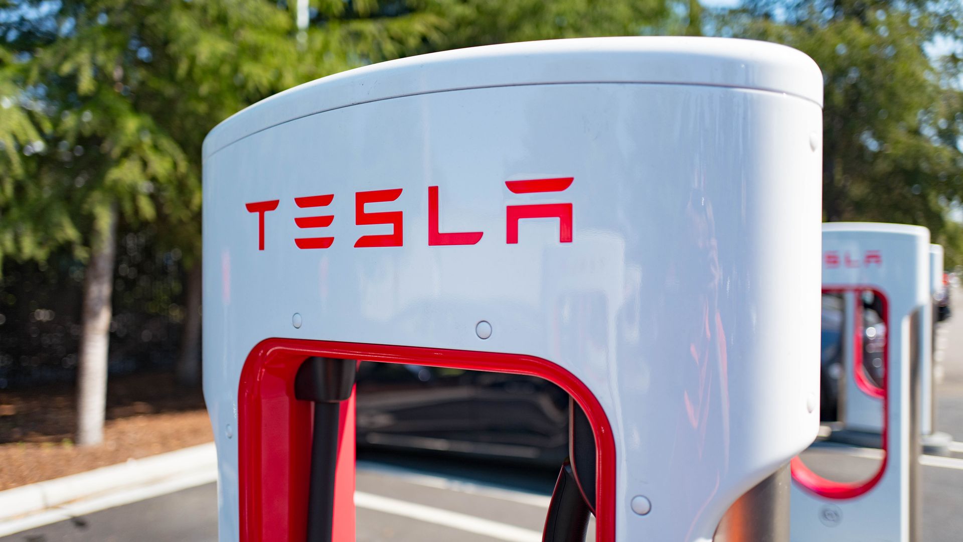 This image shows a Tesla supercharger in a parking lot.