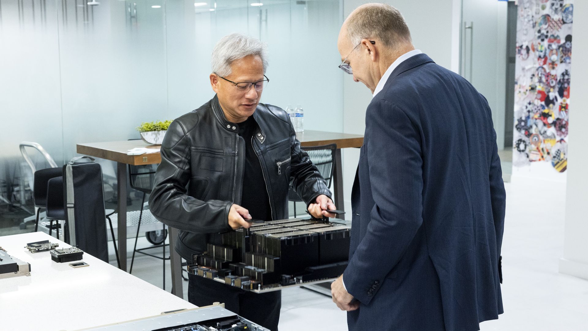 Nvidia CEO Jensen Huang shows an Nvidia module to Axios' Mike Allen in Washington on Friday. Photo: Kristoffer Tripplaar/Axios
