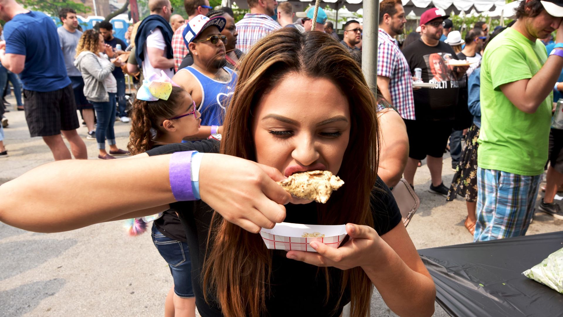 An attendee trying a chicken wing at Wing Out Chicago 2019.