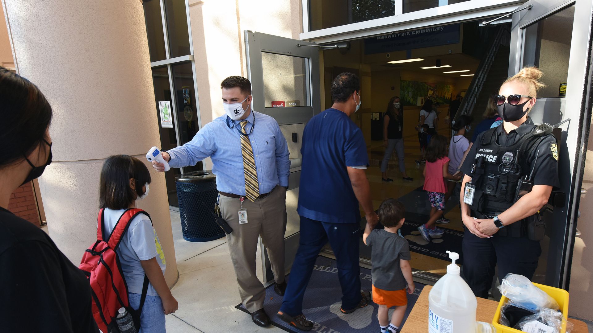Principal Nathan Hay performs temperature checks on students as they arrive on the first day of classes at Baldwin Park Elementary School in Florida.
