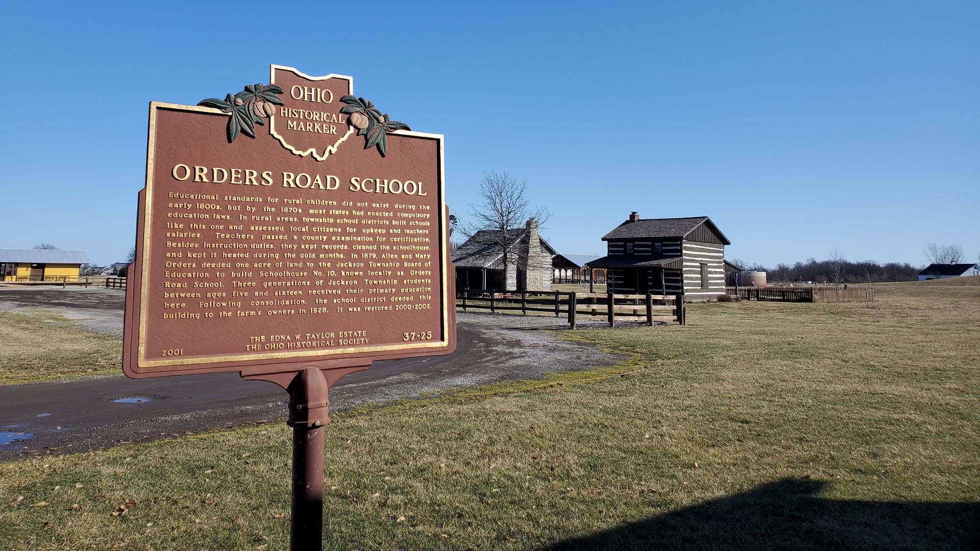 A historical marker is pictured next to an 1800s-themed village.
