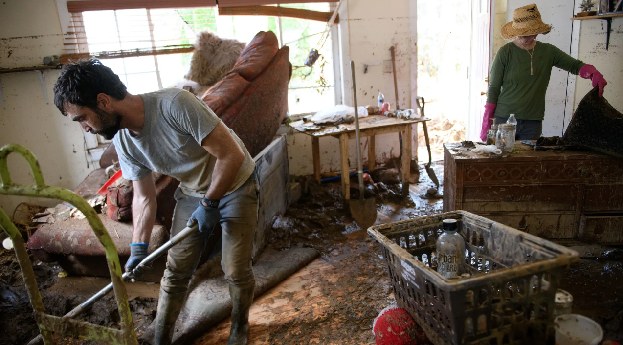 Mark Dempsey in his Swannanoa, North Carolina, home with Emily Ogburn as they salvage items and clean the property on Wednesday.