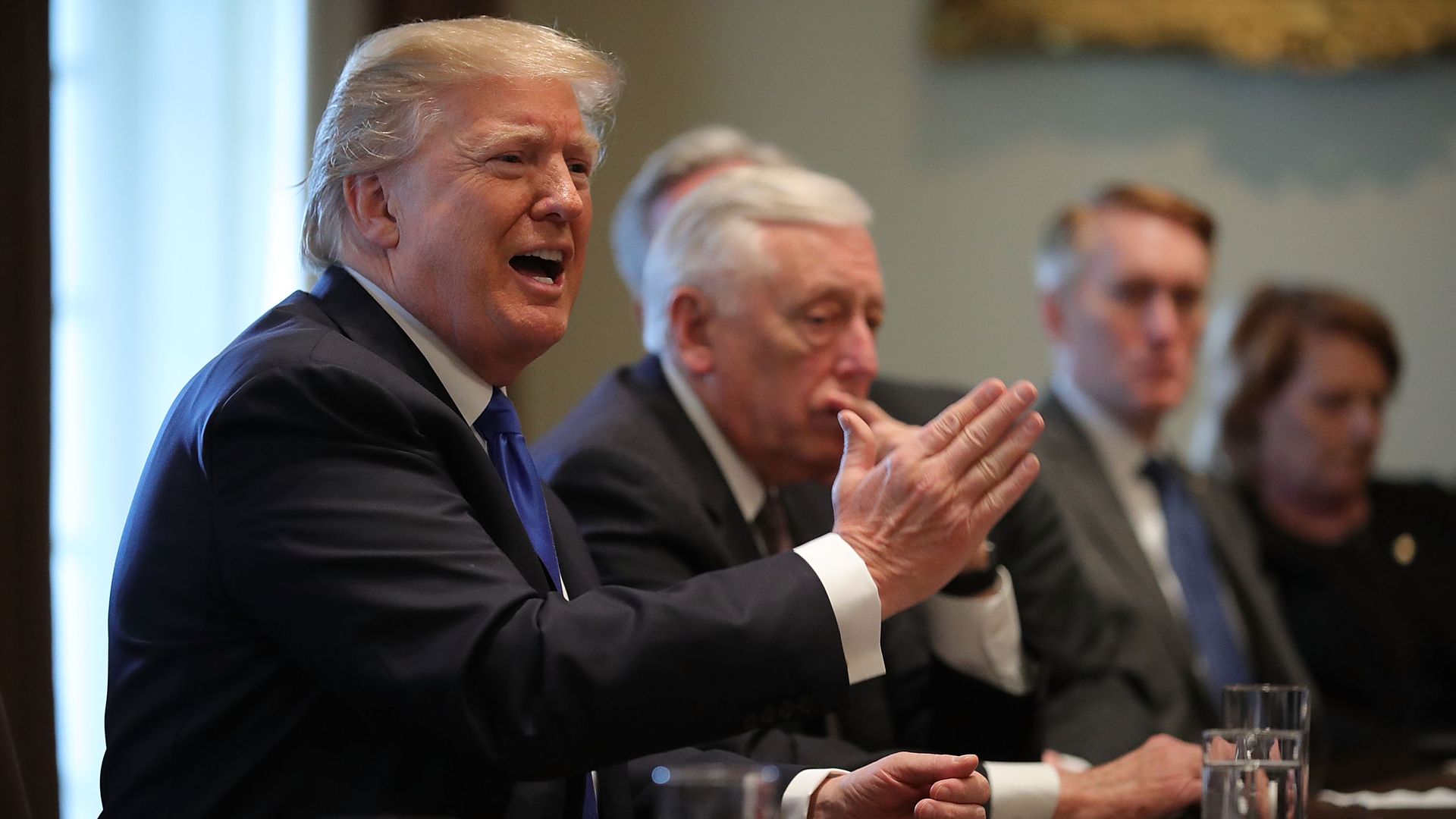 Trump slices the air with his hand at an immigration meeting