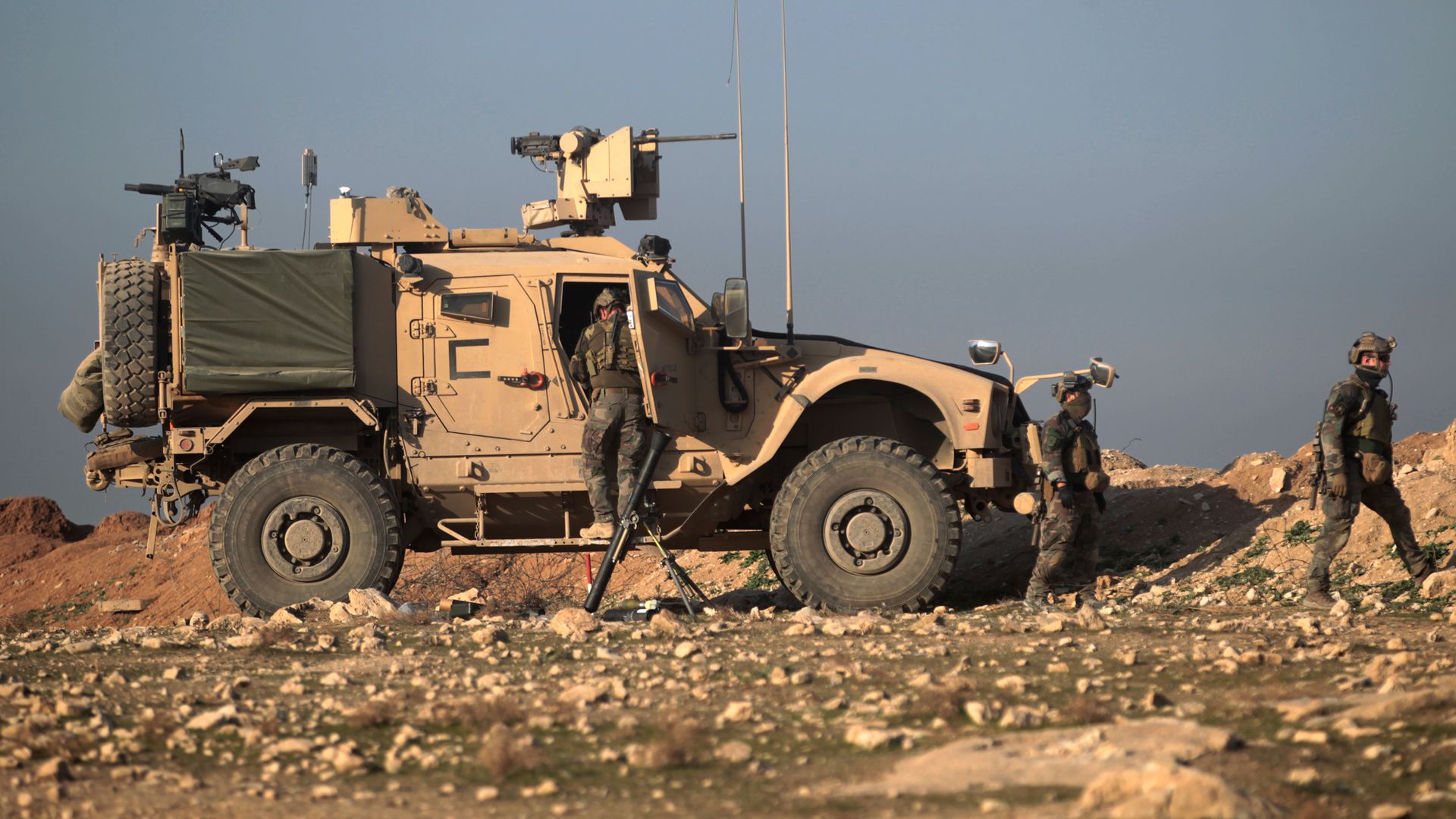 Soldiers get out of an armored vehicle