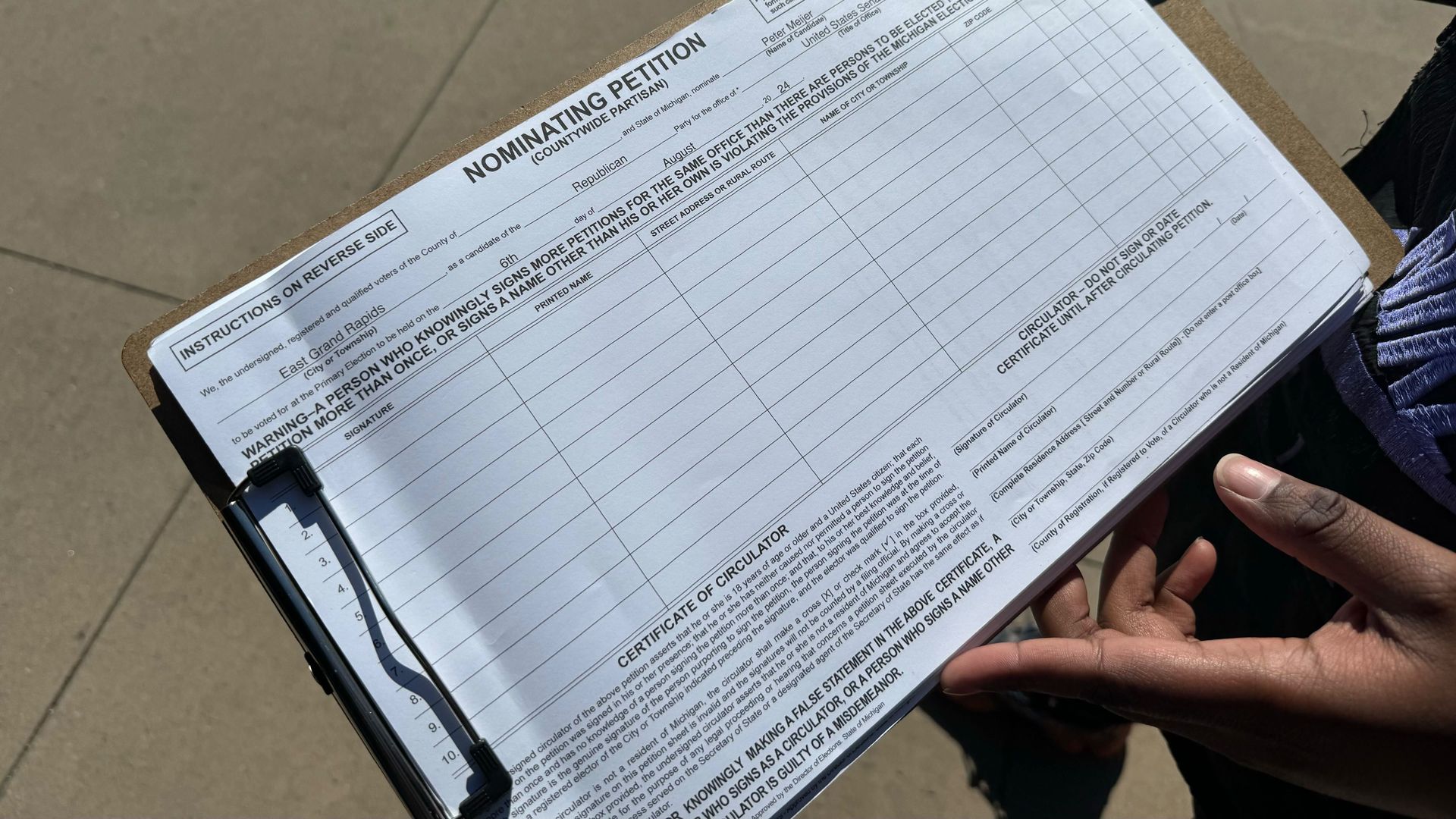 A nominating petition for former U.S. House Rep. Peter Meijer is circulated by a paid gatherer outside Eastern Market in March. 