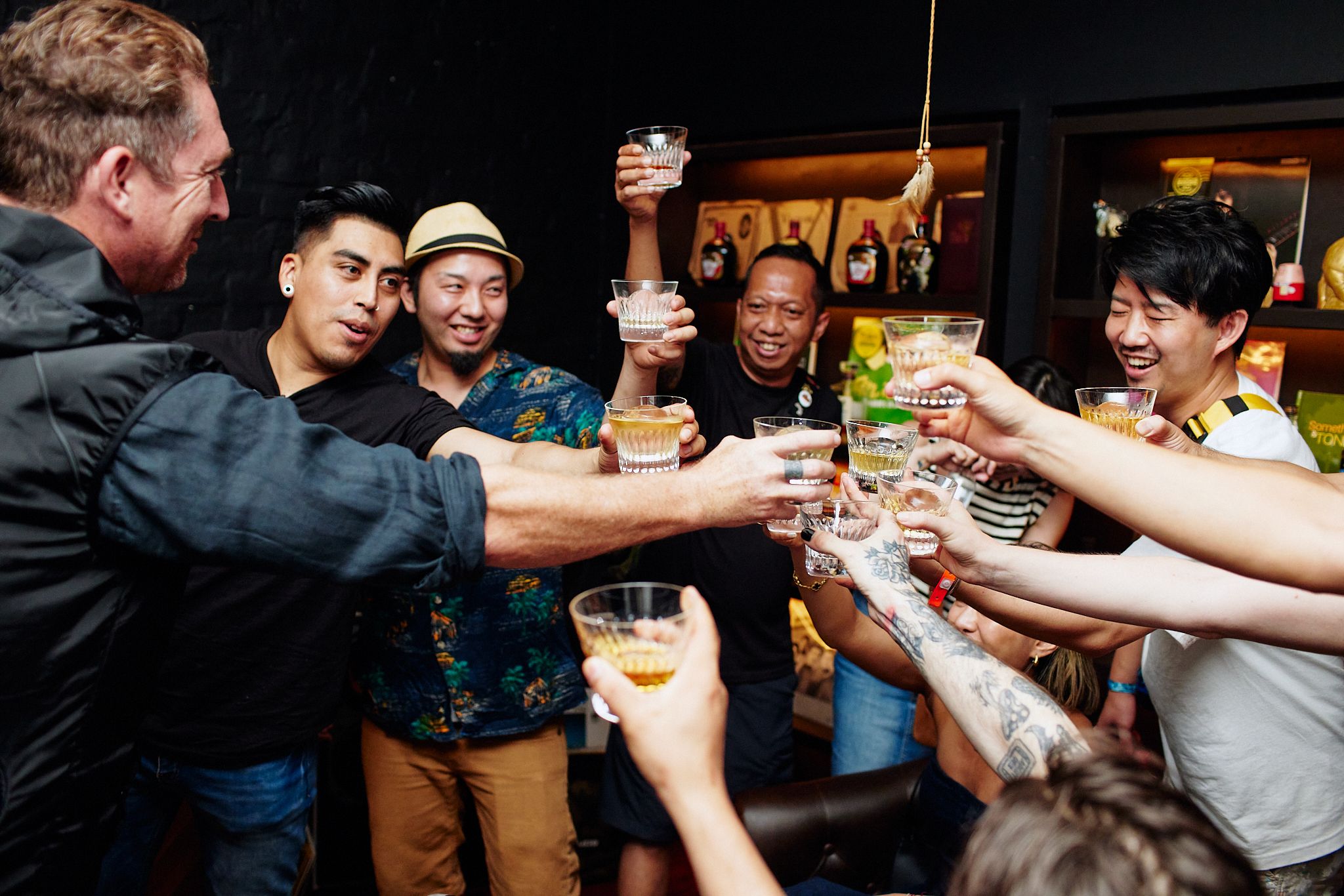 A group of people toast while clinking their drinks together.
