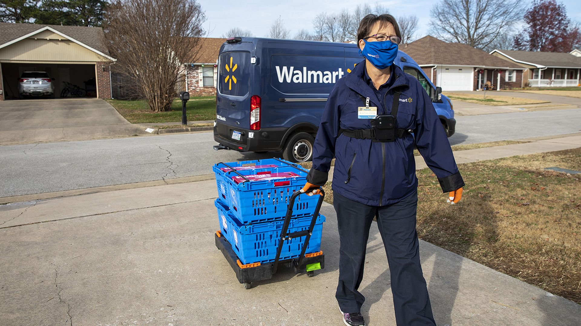 A Walmart worker delivering groceries to someone's home.