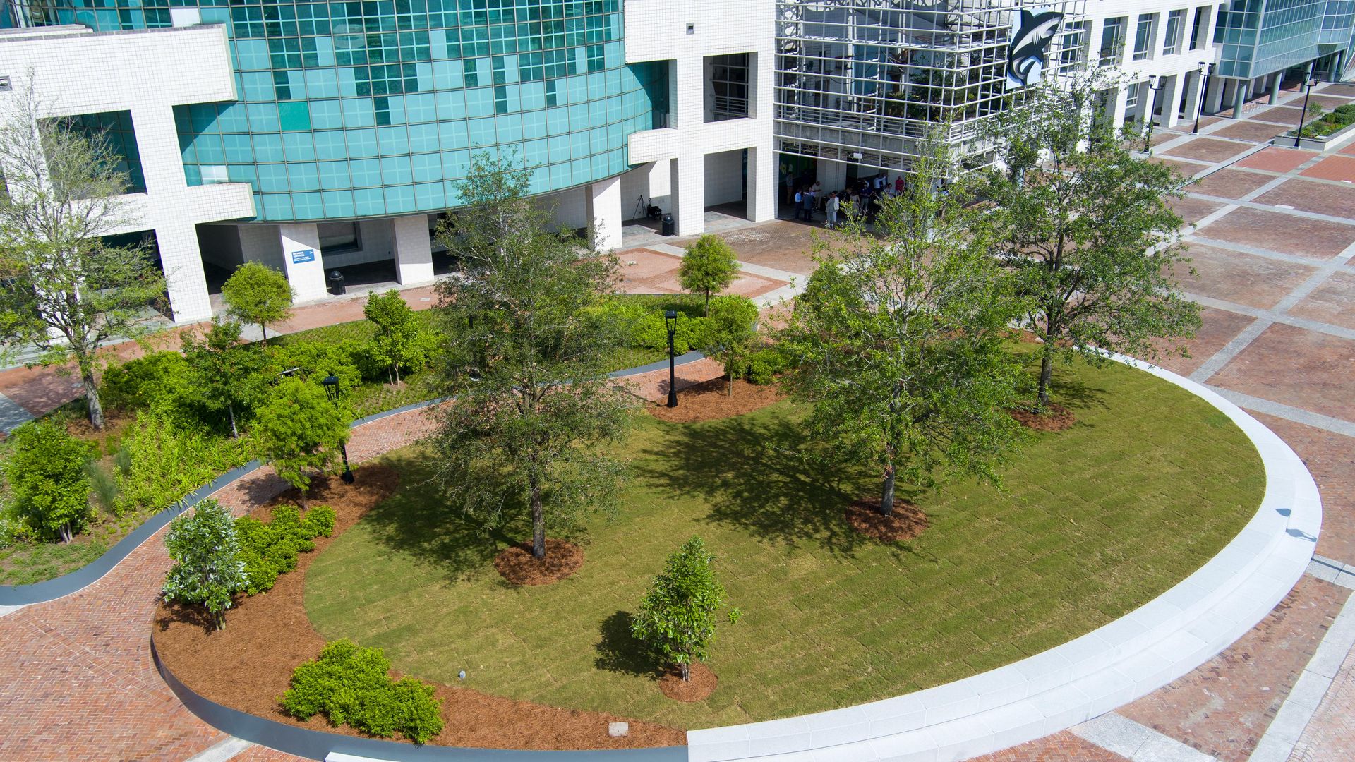 A grassy area with trees is in front of the Audubon Aquarium in New Orleans.