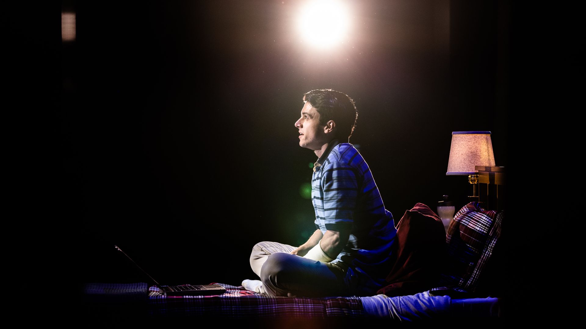 Anthony Norman sits on a bed on a stage in "Dear Evan Hansen."