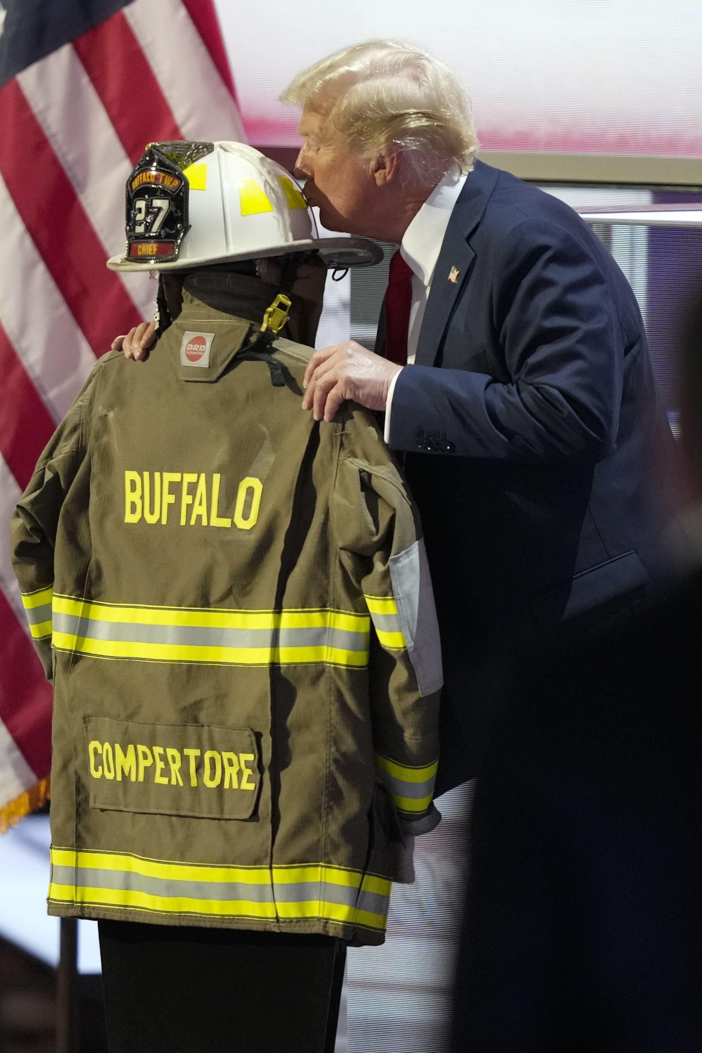 Trump kisses the helmet of Corey Comperatore, the retired firefighter who was fatally shot during Saturday's assassination attempt.