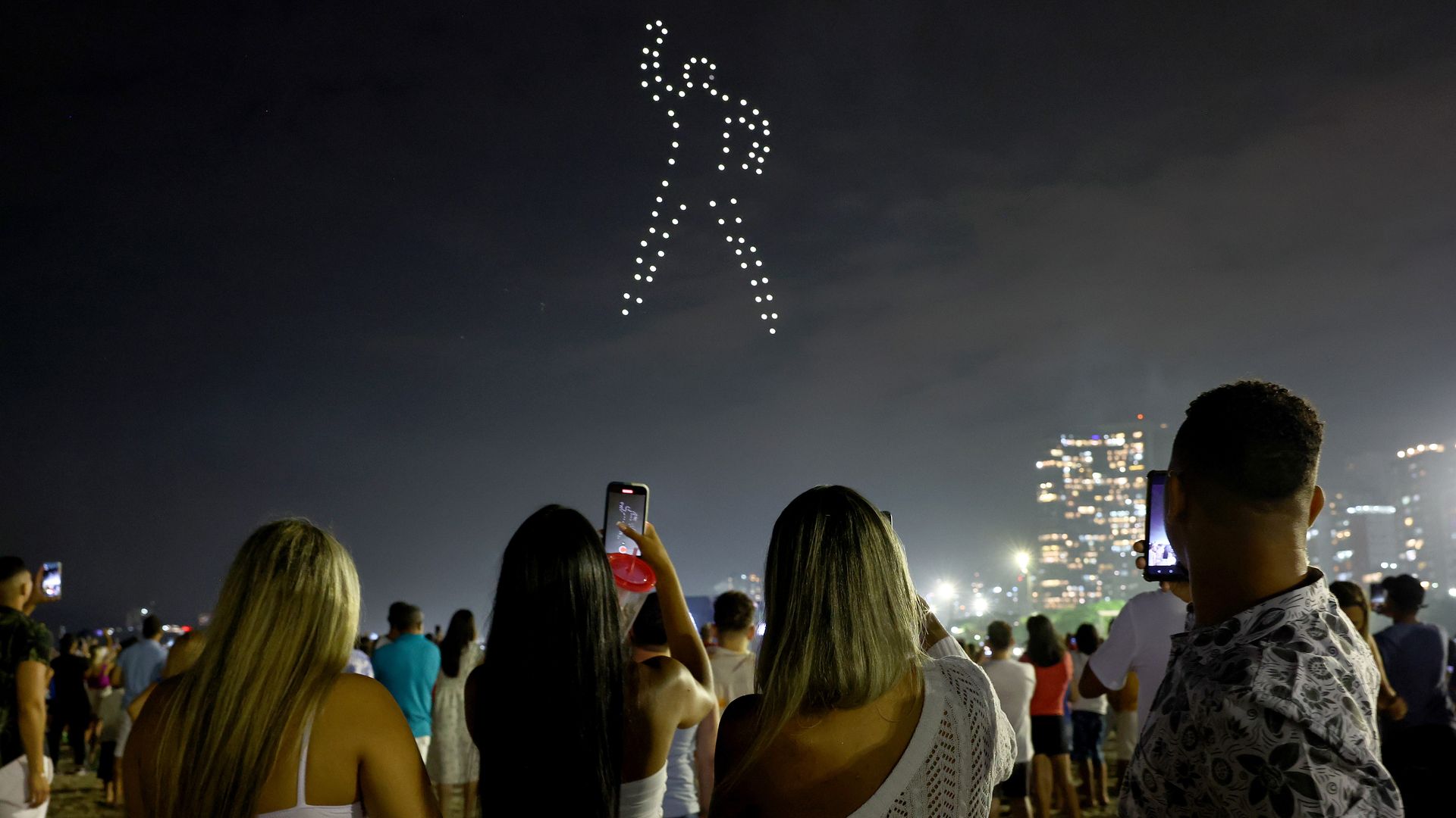 People watch a drone show dedicated to Pele during New Year's Eve festivities.