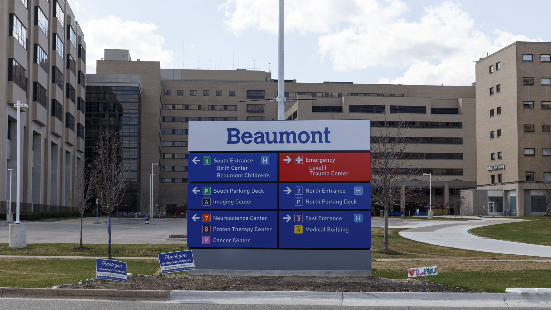 A blue Beaumont hospital sign with the hospital buildings in the background.