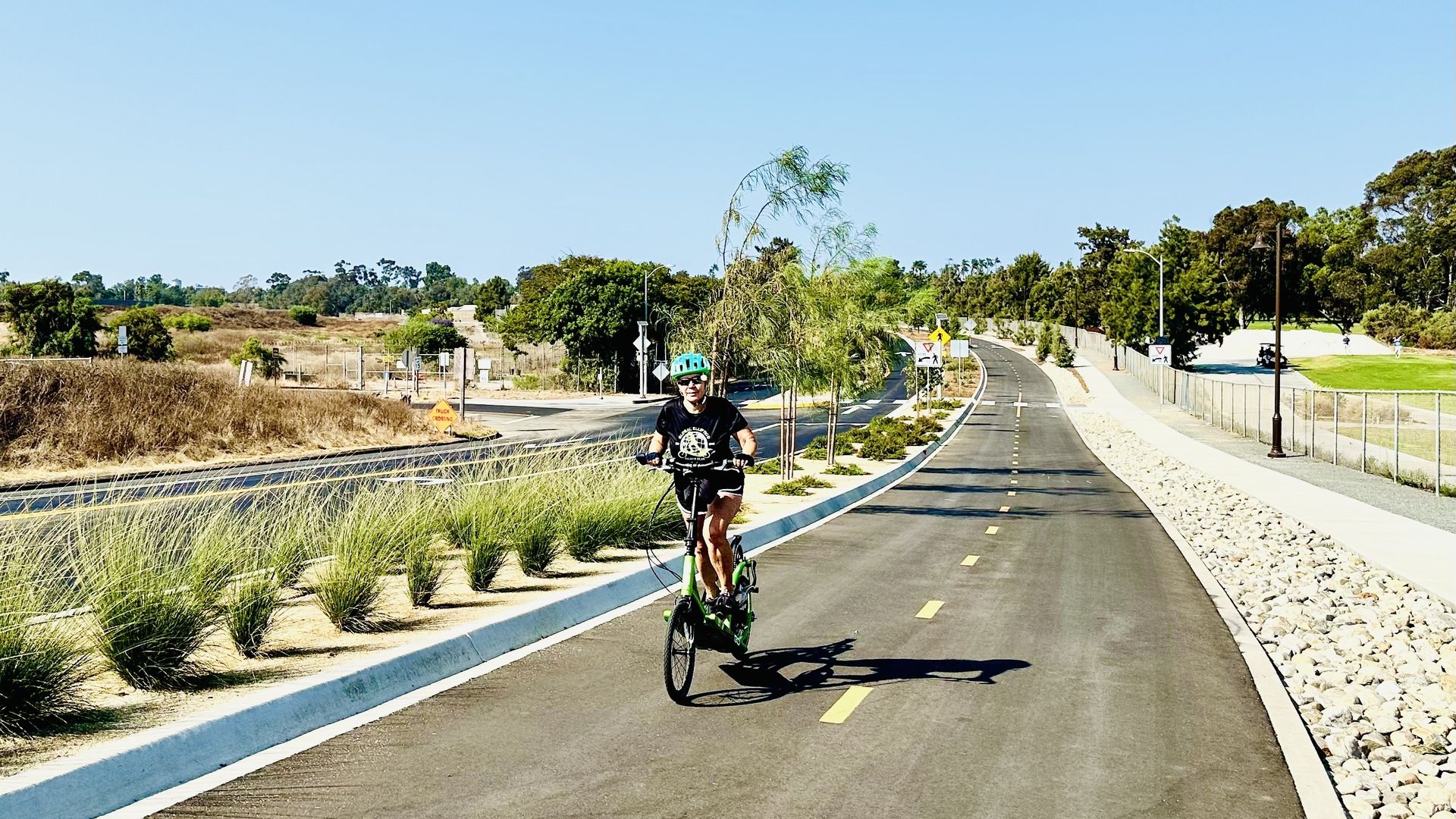 A cyclist riding south on the new Pershing Bikeway through Balboa Park