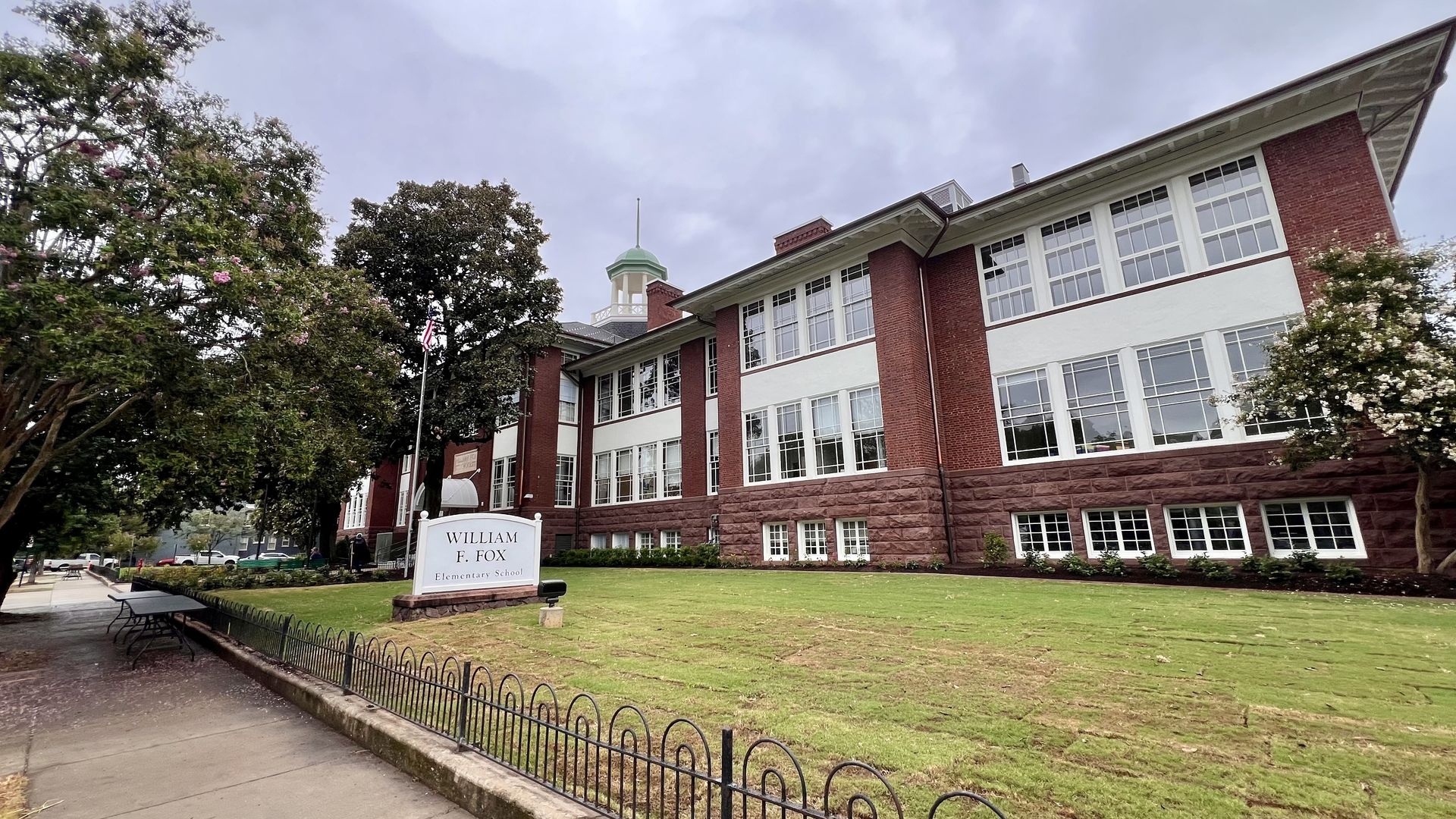 a pic of a school building with a placard out front that says "William Fox" 