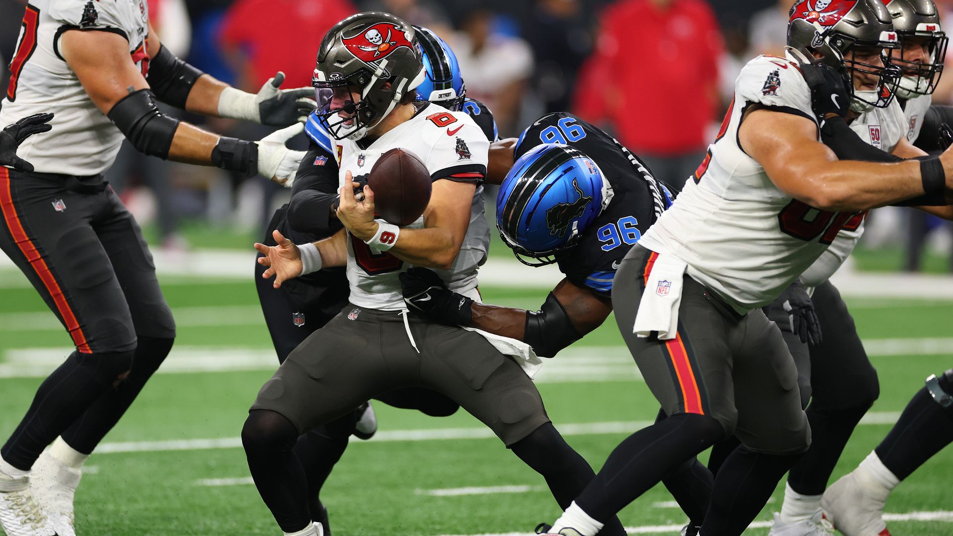 Detroit's defense swarms Tampa Bay quarterback Baker Mayfield. 