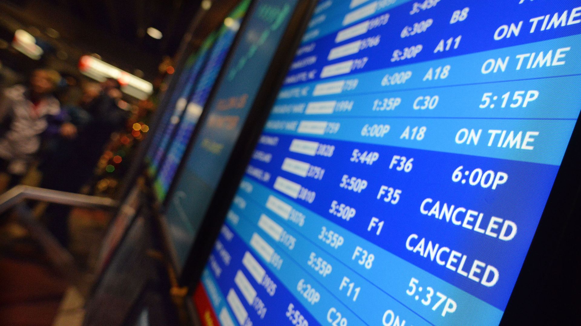 Flight departure displays of delayed and canceled fights at Philadelphia International Airport.