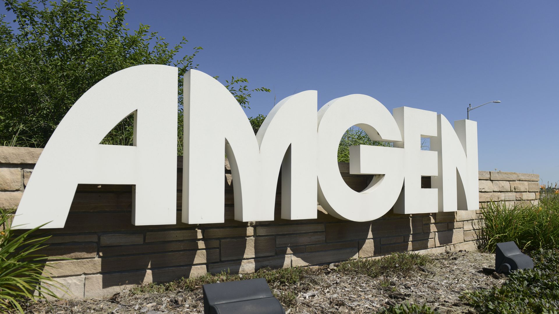The white Amgen logo and sign outside of the company's headquarters.
